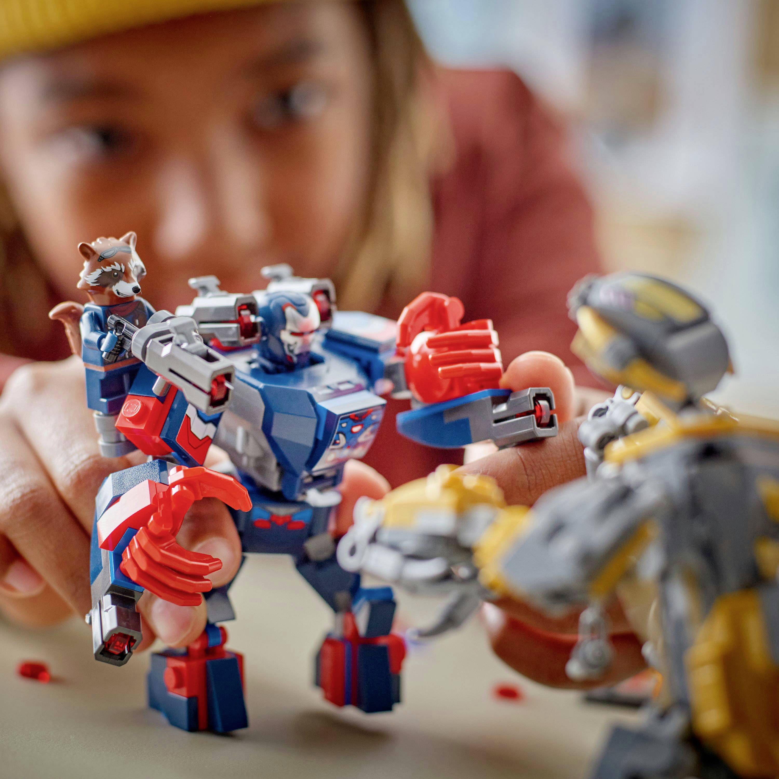 Dítě si hraje s barevnými hračkami roboty a soustředěně propojuje modrého a červeného robota s rozpažením proti žlutému.