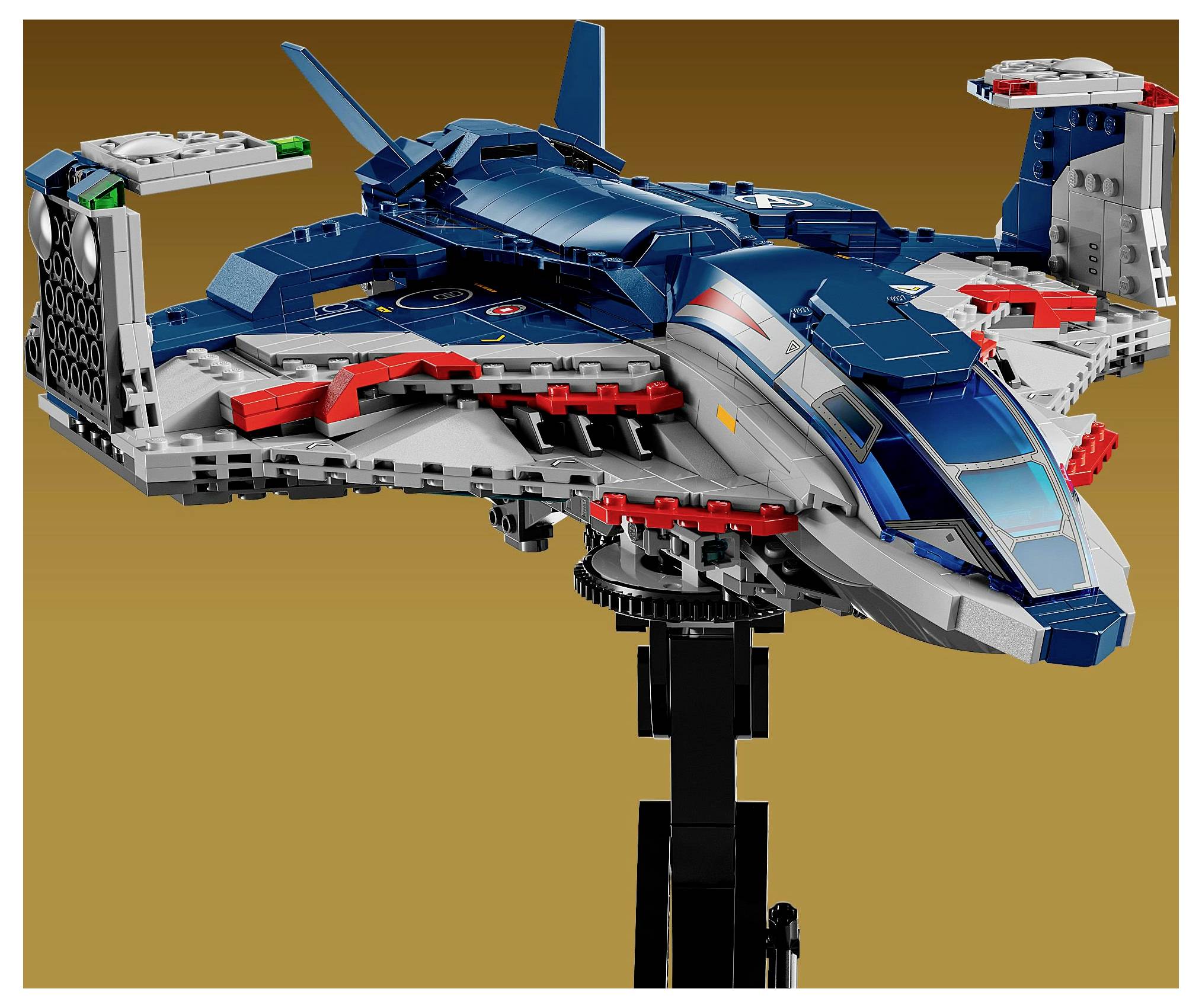 Detailní model futuristické vesmírné lodi v modro-šedých barvách, s křídly a ocasními plochami. Je umístěn na černém podstavci.