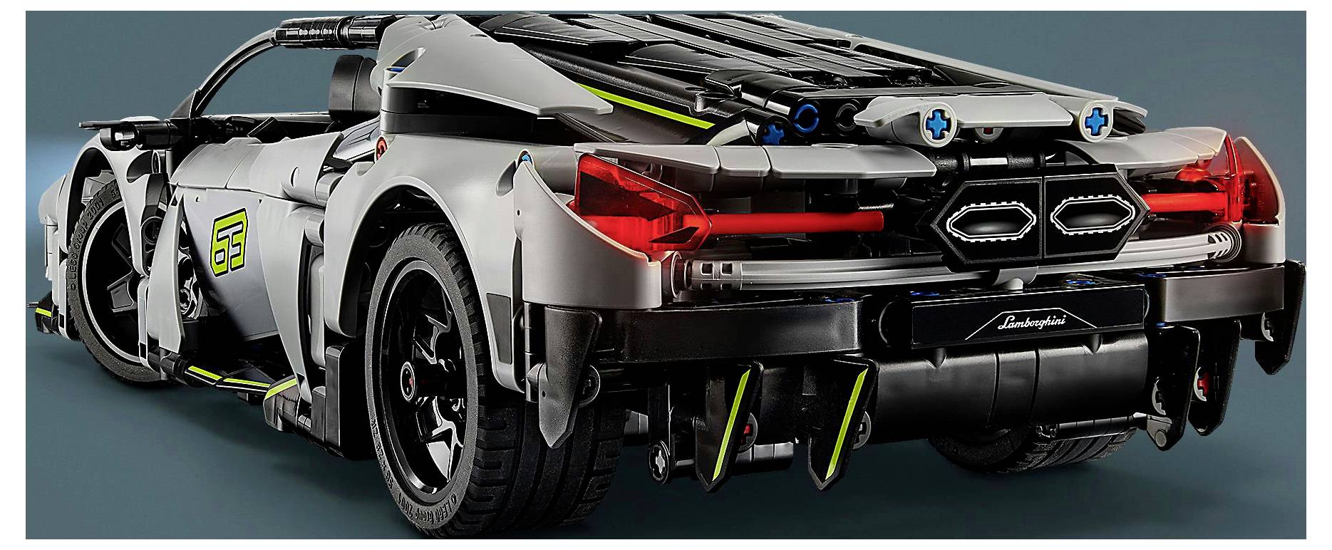 Detailní model sportovního vozu Lamborghini, zobrazující zadní design s červenými zadními světly, černými a stříbrnými panely a aerodynamickými prvky.