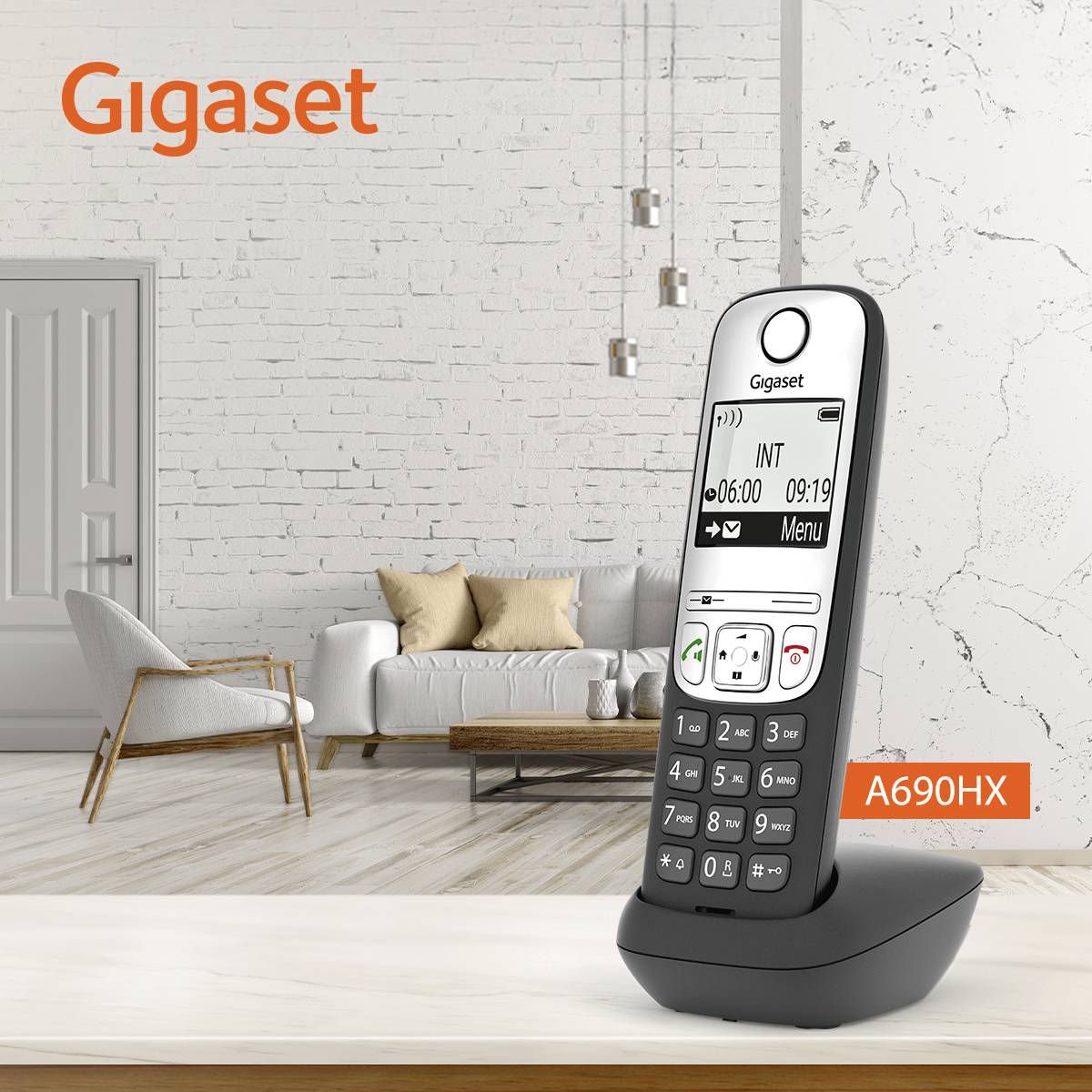 Na stole v moderním obývacím pokoji s šedou pohovkou a závěsnými lampami stojí bezdrátový telefon Gigaset A690HX.