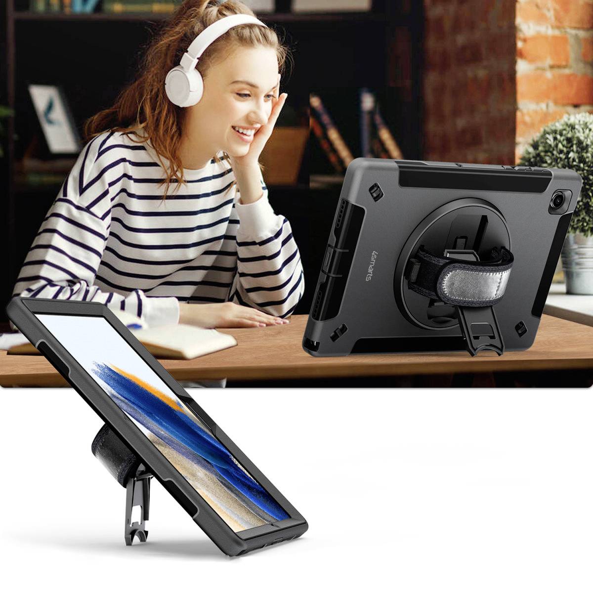 Žena s nasazenými sluchátky se usmívá při pohledu na tablet. Tablet má odolný obal a stojí na stole.