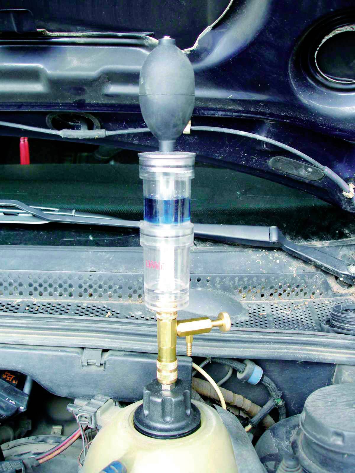Analyzátor výfukových plynů pro automobily s odběrným balónkem je připevněn u otevřeného motorového prostoru vozidla.