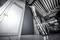 Osoba stojí na vysokém žebříku a pracuje na stropě v moderní garáži nebo dílně s kovovými konstrukčními prvky.