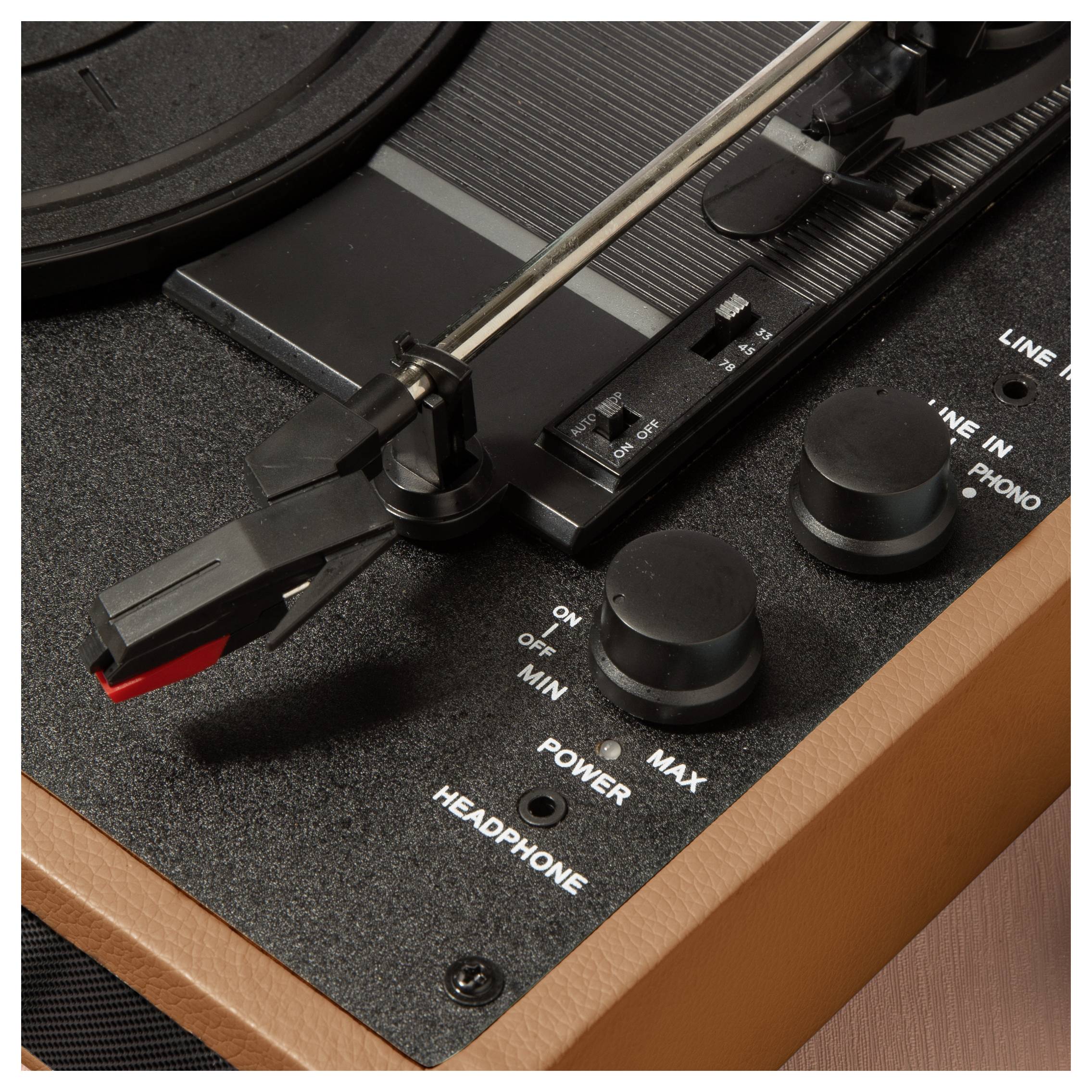 Gramofon v detailním záběru s ramenem, jehlou a ovladačem hlasitosti. Jsou viditelné také sluchátková a zapínací tlačítka.