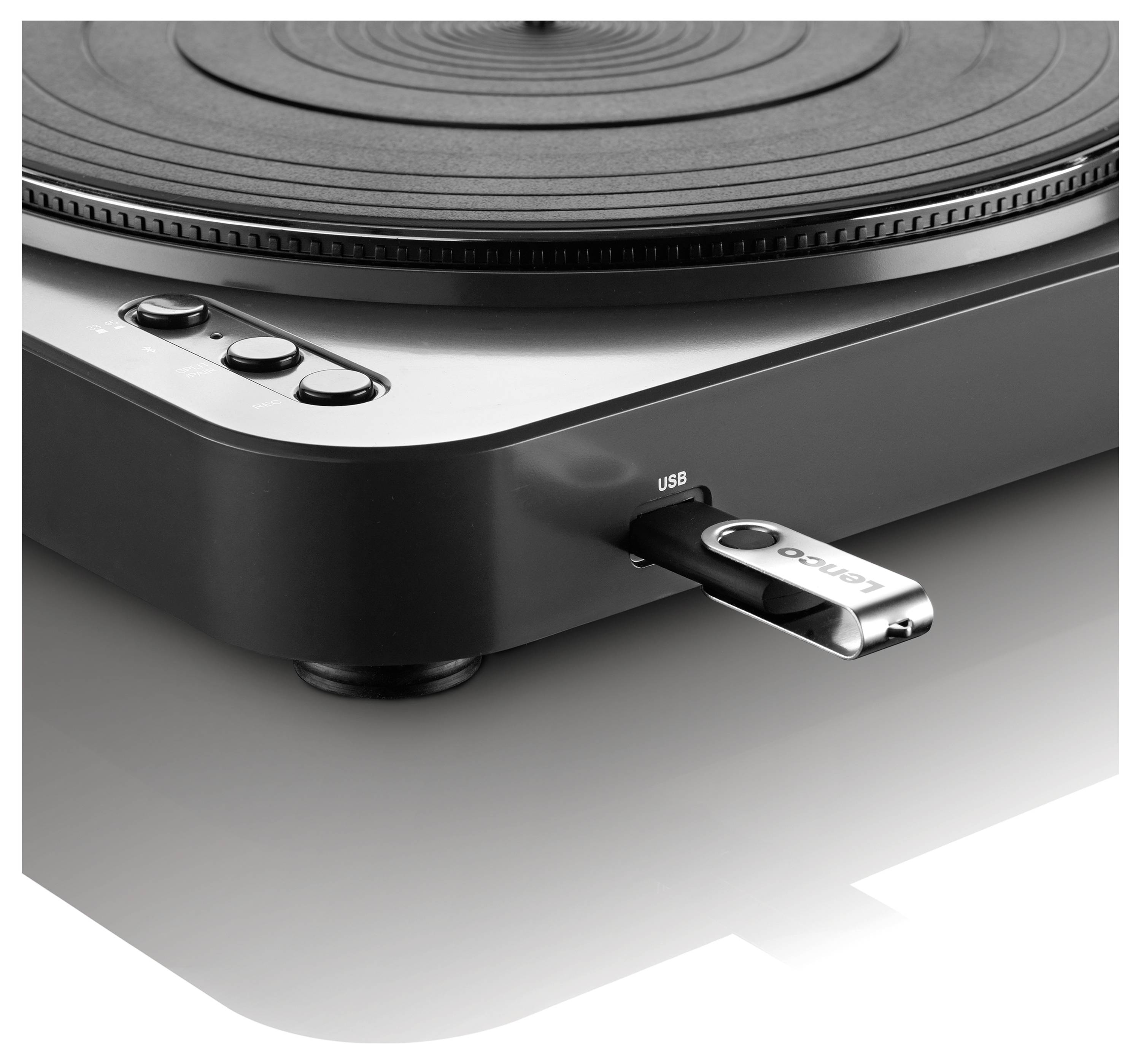 Gramofon s USB flash diskem, zaměřený na přípojné porty a ovládací prvky. Moderní design v černé a stříbrné barvě.