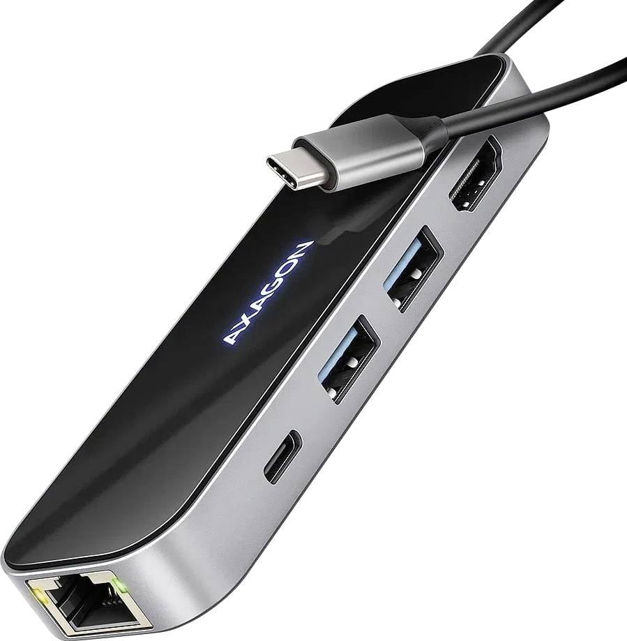 Černý adaptér s několika USB a HDMI porty, připojený pomocí kabelu USB-C. Název značky "Hexagon" je umístěn na horní straně.