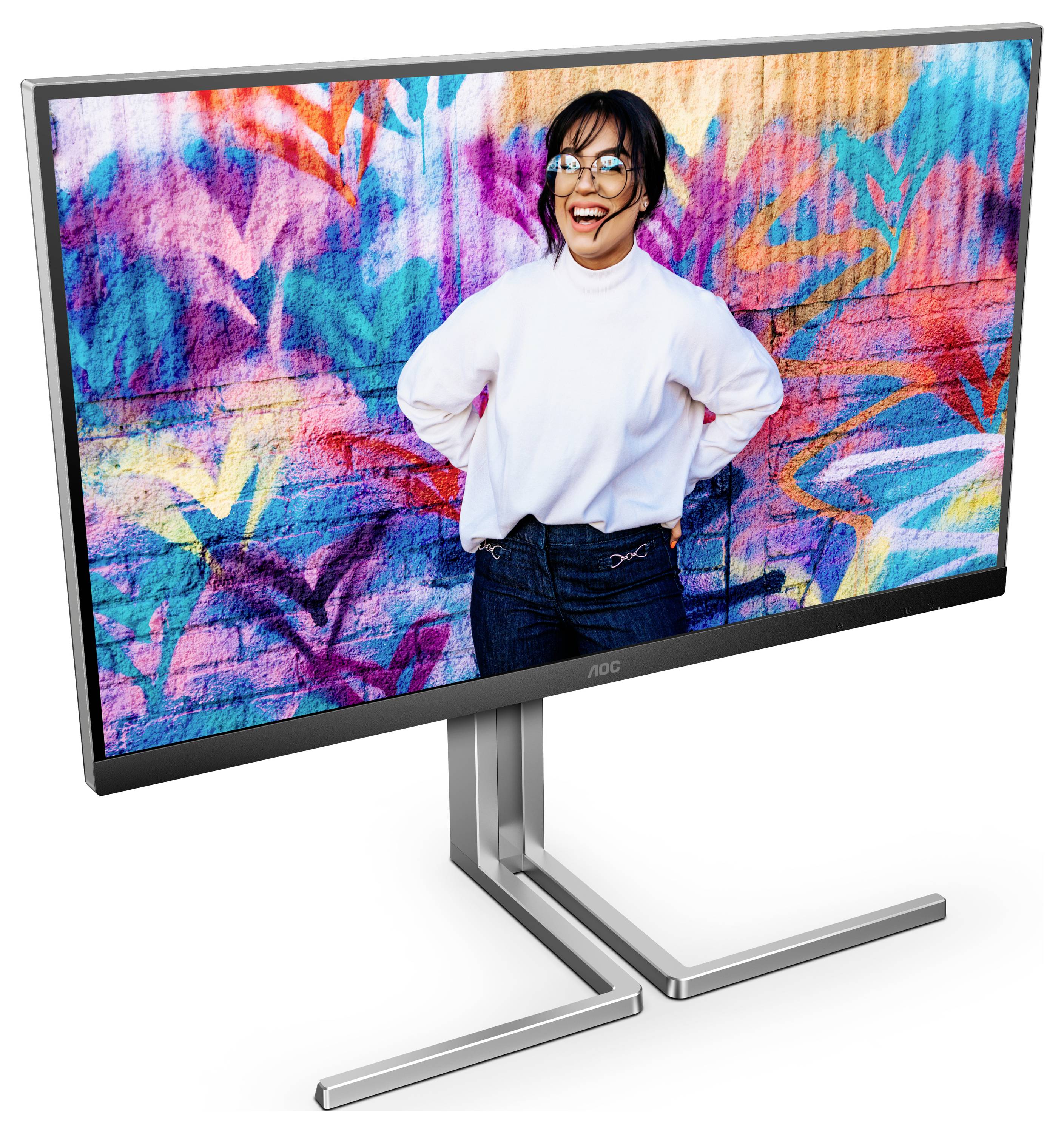 Počítačový monitor zobrazuje usměvavou osobu před pestrobarevnou grafickou stěnou. Monitor je umístěn na moderním stříbrném stojanu.