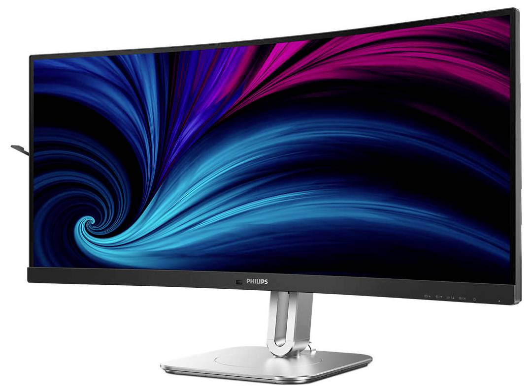 Zakřivený počítačový monitor od Philips s pozadím v zářivě modré a magentové barvě, umístěný na stříbrném stojanu.