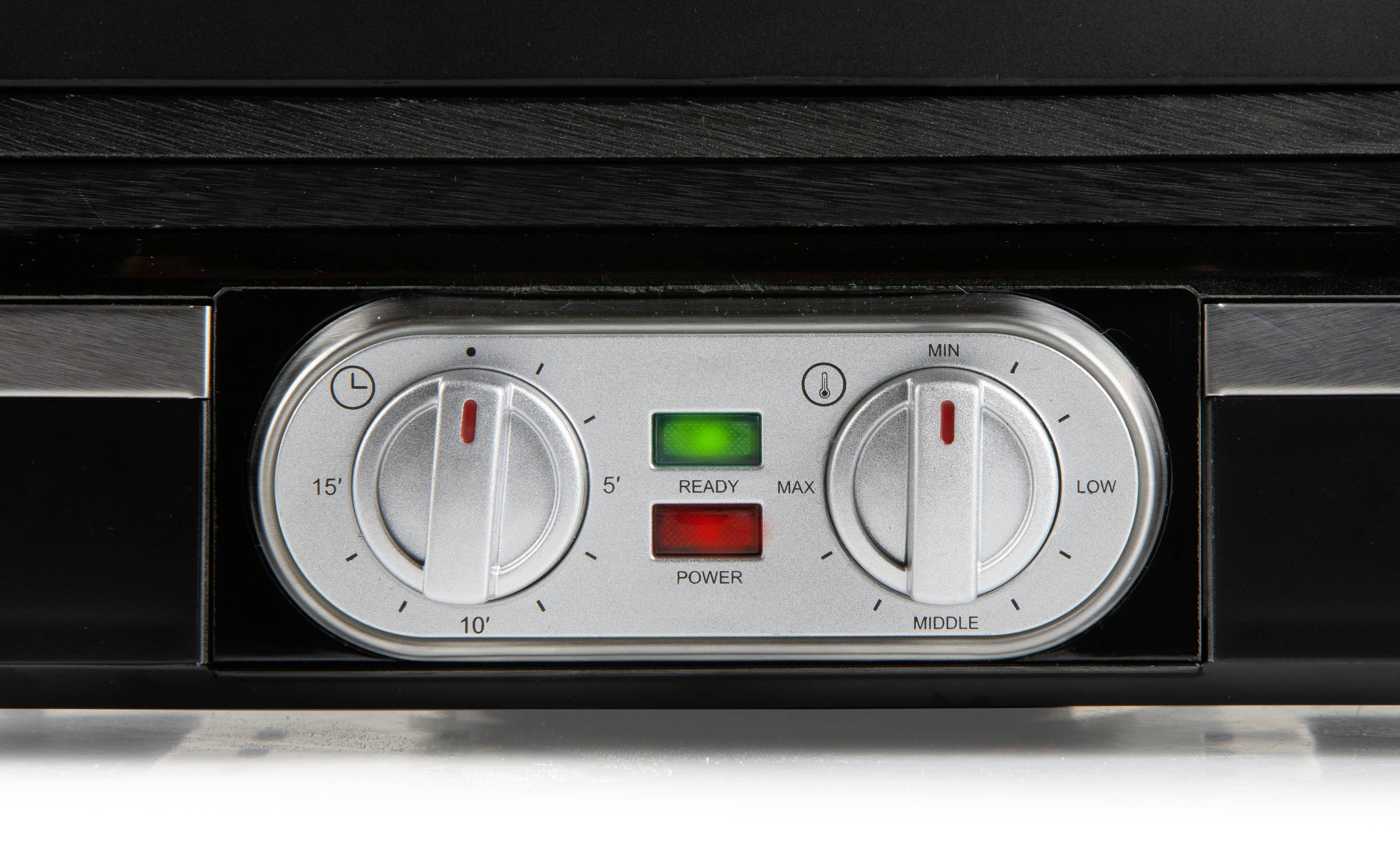 Detailní záběr ovládacího panelu se dvěma otočnými knoflíky a zelenou kontrolkou uprostřed, která signalizuje pohotovostní stav.