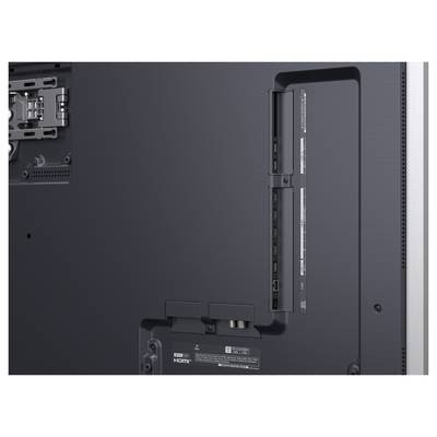 Zadní strana černého elektronického zařízení zobrazující různé vstupní porty, včetně HDMI a USB, pro připojení a multimediální možnosti.