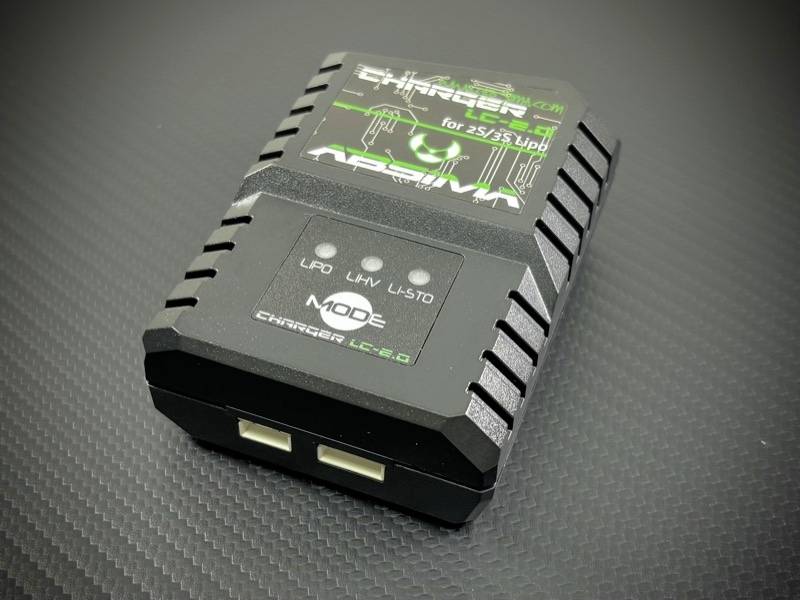 Černá nabíječka se dvěma USB porty, se zeleným potiskem na horní straně. Text: 'Charger LC-2.0', vhodná pro 2S/3S LiPo baterie.