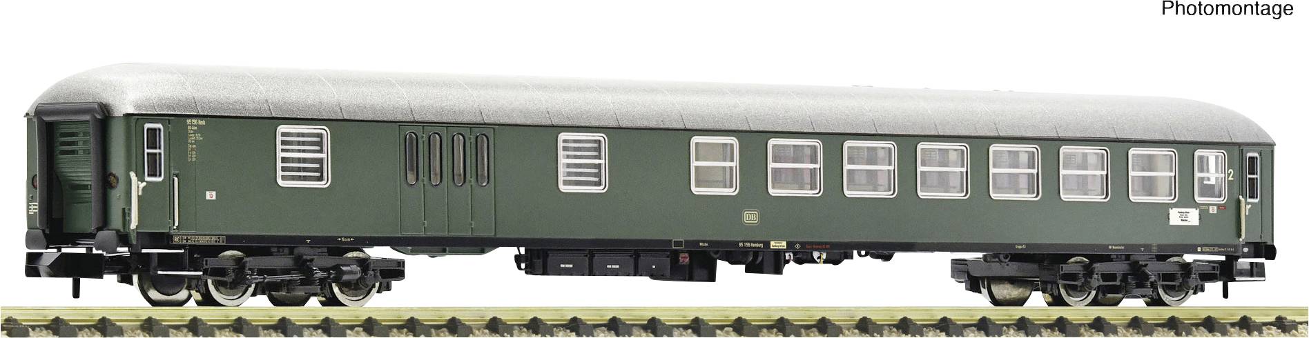 Zelený modelový železniční vagon na kolejích z pohledu z boku.