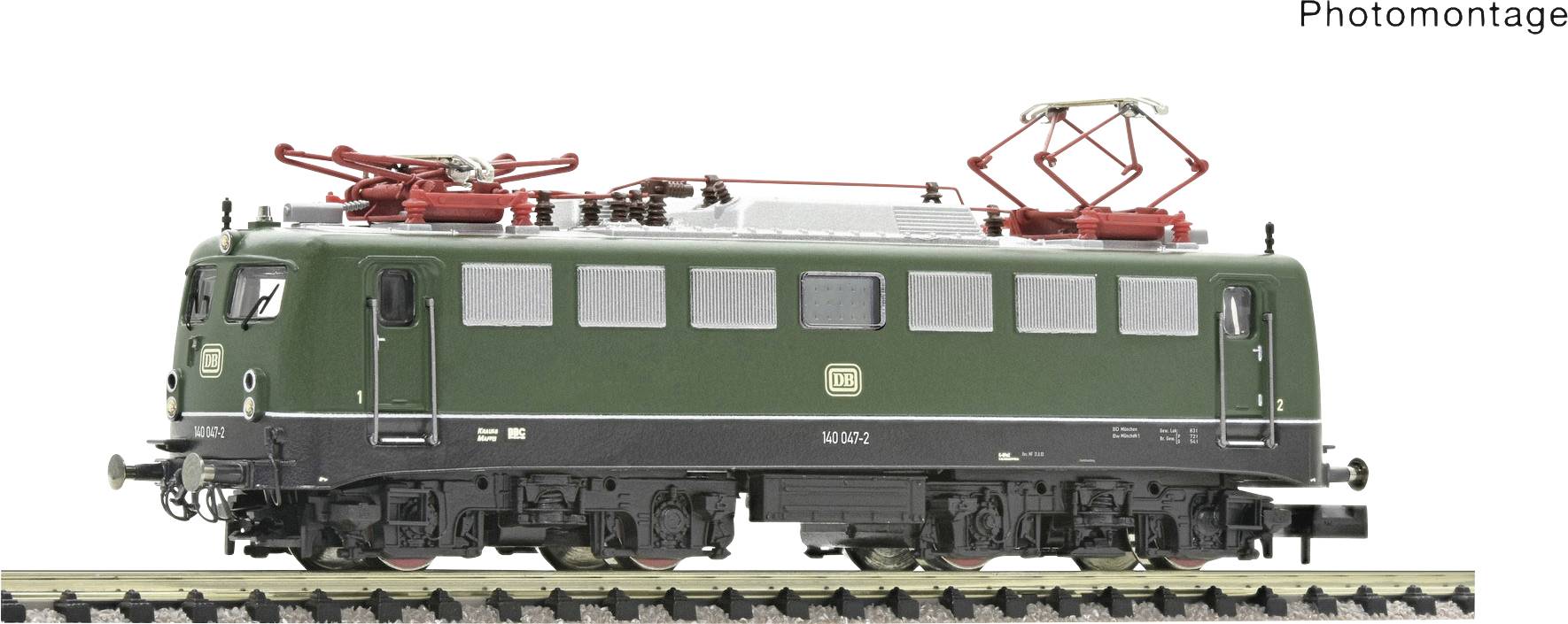 Zelený model německé lokomotivy s červenou střechou a stříbrným sběračem na kolejích, pohled z boku.