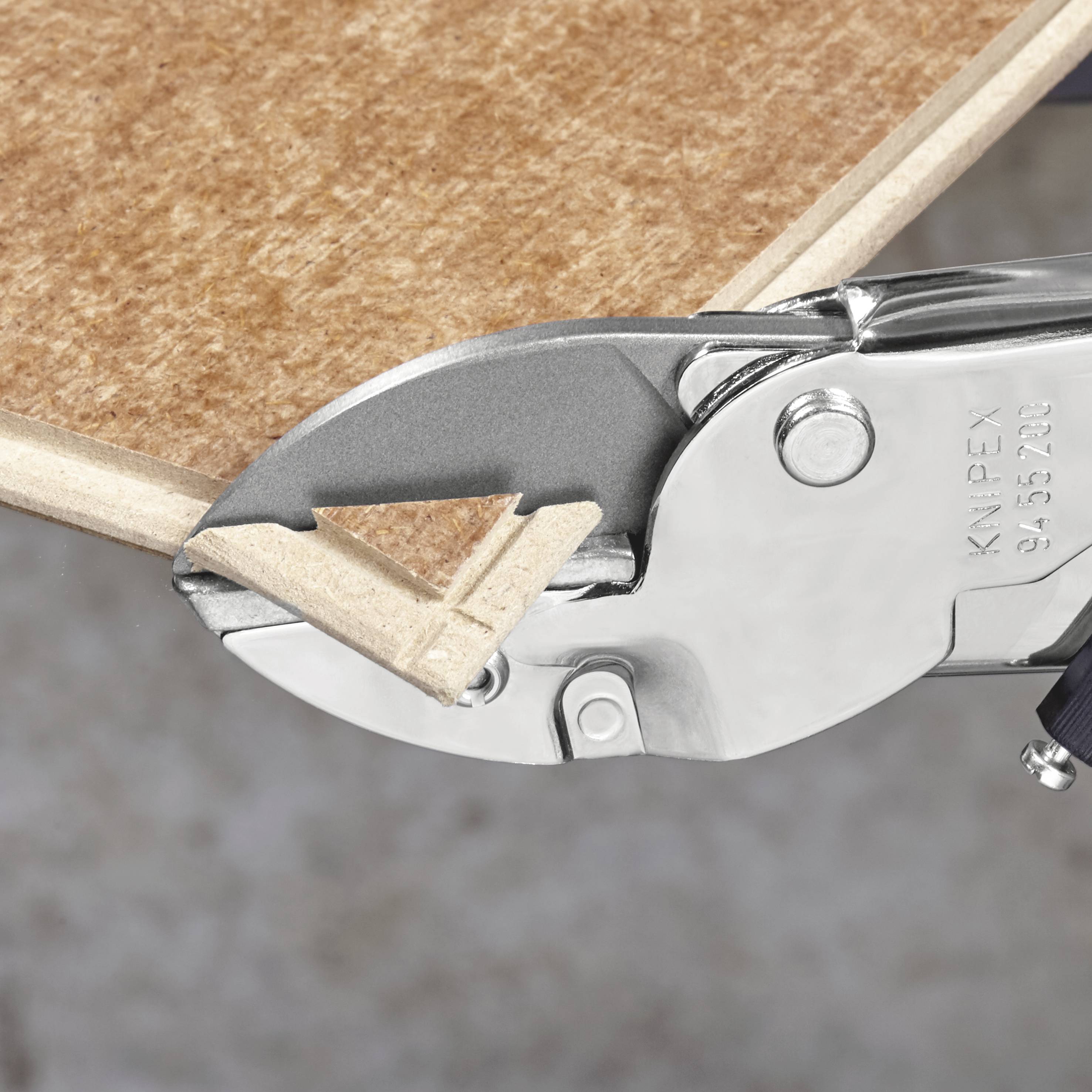 Kovový řezací nástroj prořízne dřevěnou desku. Obrázek ukazuje přesný řez nástroje na okraji materiálu.