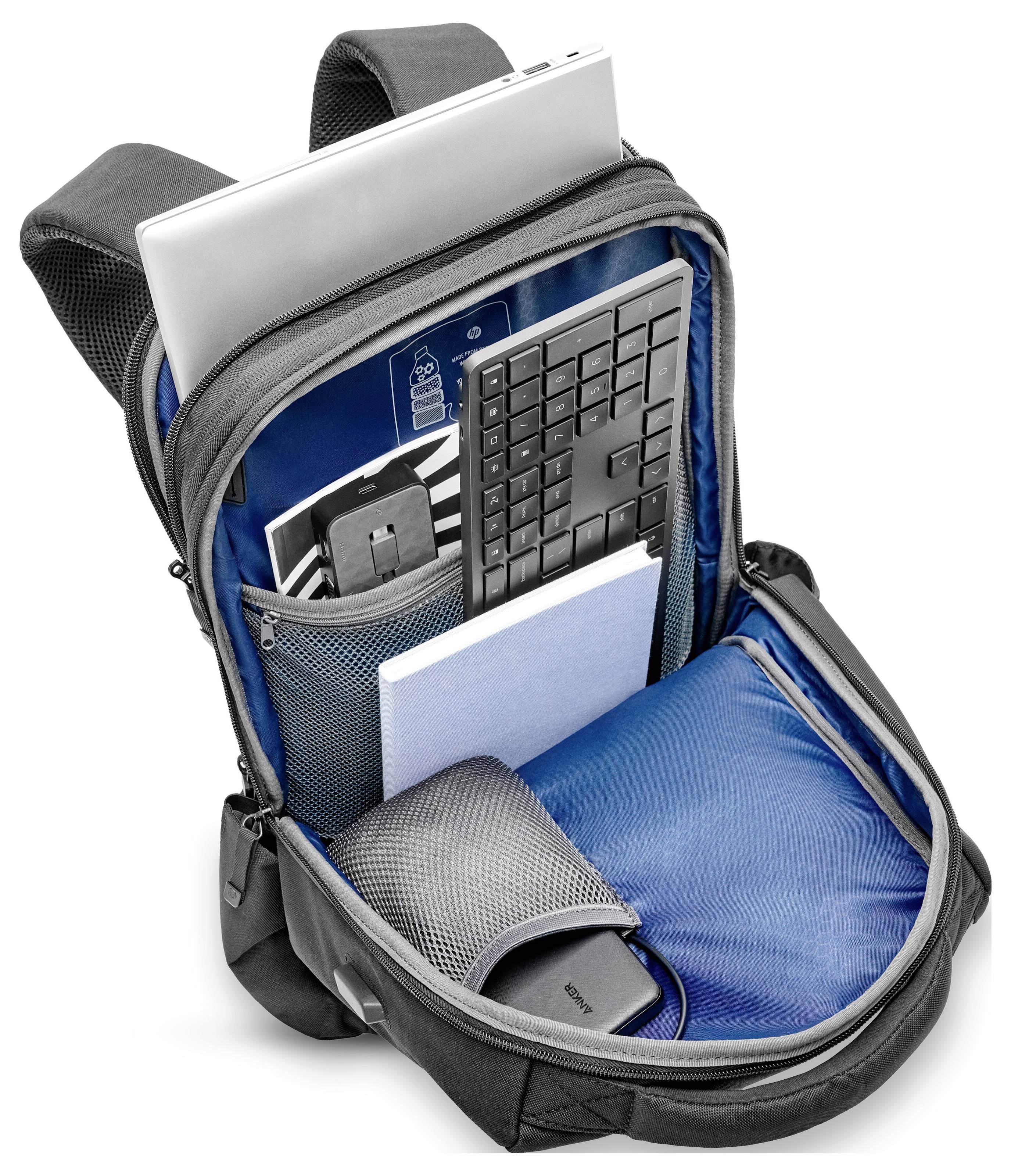 Otevřený batoh s vnitřním prostorem pro notebook, klávesnici, poznámkový blok a sluchátka ukazuje praktické řešení pro uložení a organizaci technických doplňků.