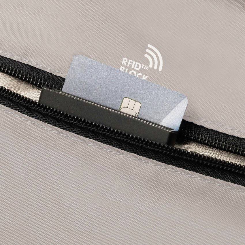 Kreditní karta je z části zasunutá do tašky se zipem. Na tašce je nápis 'RFID BLOCK', který poukazuje na ochranu před RFID.