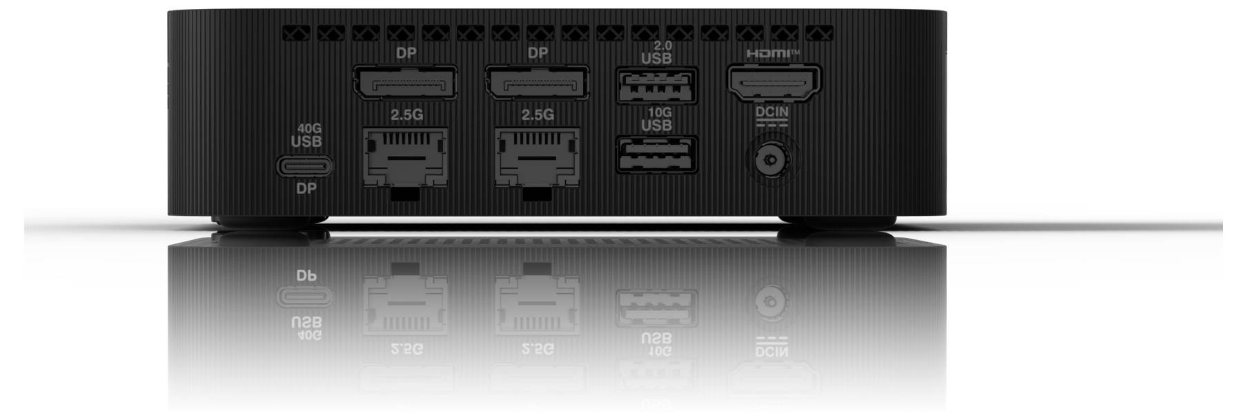 Pohled zezadu na černé zařízení s konektory pro DP, HDMI, USB a síť. Zrcadlový efekt zajišťuje symetrický vzhled.