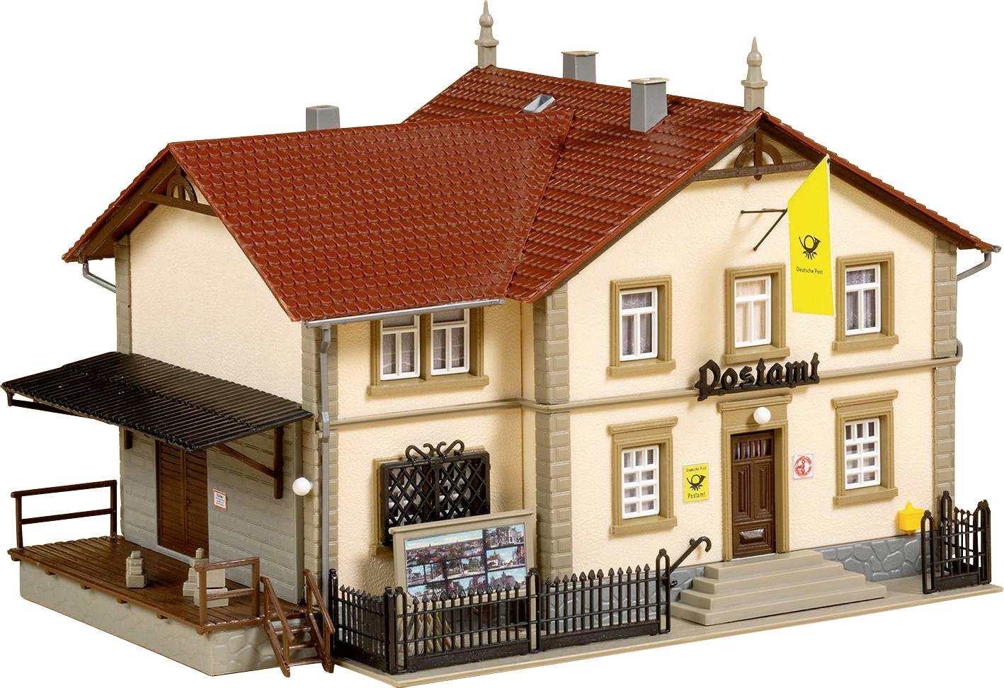 Model budovy pošty s červenými tahovými střechami, žlutým logem a cedulemi. Schodiště a zábradlí vedou k vstupním dveřím.