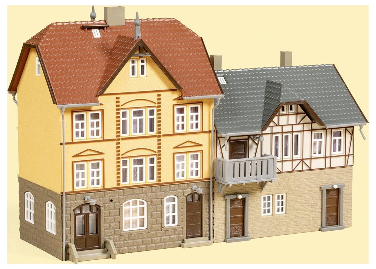 Dva modelové domy ve tradičním německém hrázděném stylu, jeden žlutý se střechou červené barvy a druhý béžový s šedou střechou.