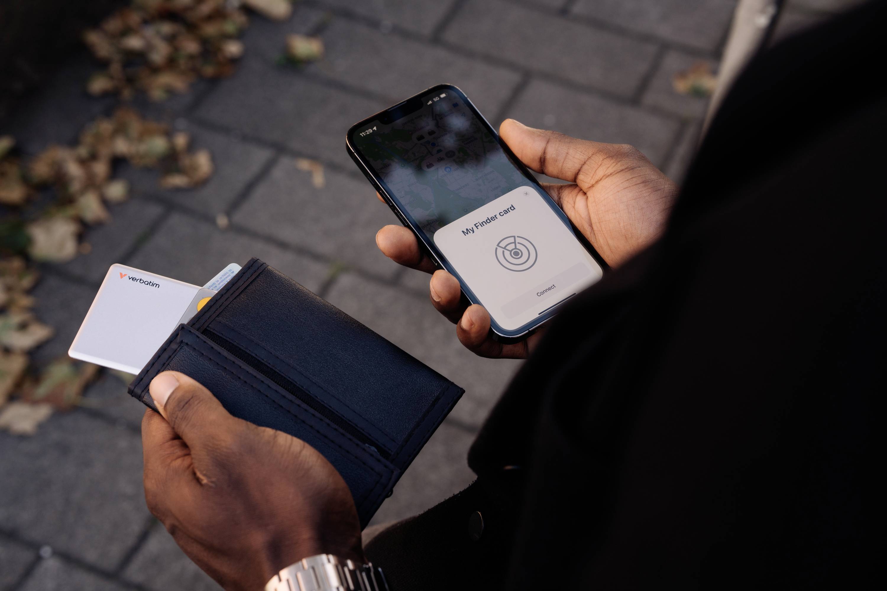 Osoba drží smartphone a otevřenou peněženku. Na smartphonu je zobrazena platba NFC.