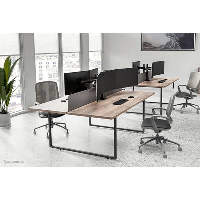 Moderní kancelářské prostory s několika pracovními stoly a monitory, ergonomické židle. Velká okna s výhledem na město v pozadí.