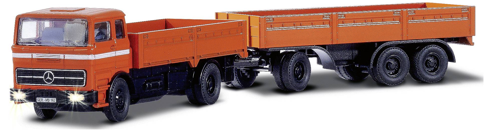 Oranžový nákladní vůz s přívěsem jede, přední světla jsou rozsvícená. Nákladní vůz má hvězdu Mercedes na chladiči.