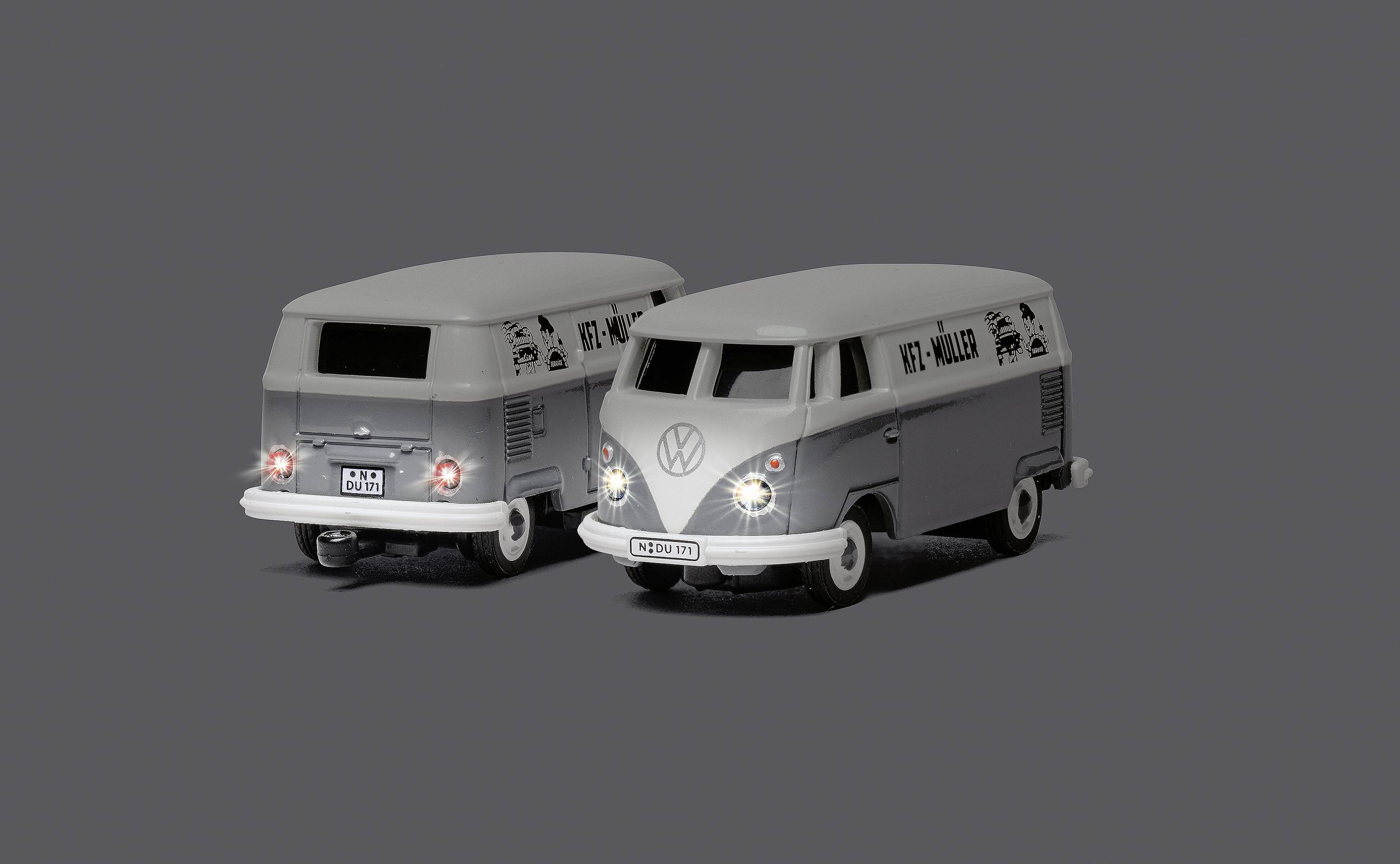 Dva šedé hračkové modely klasického VW autobusu, jeden pohled zepředu a druhý zezadu, na neutrálním pozadí.