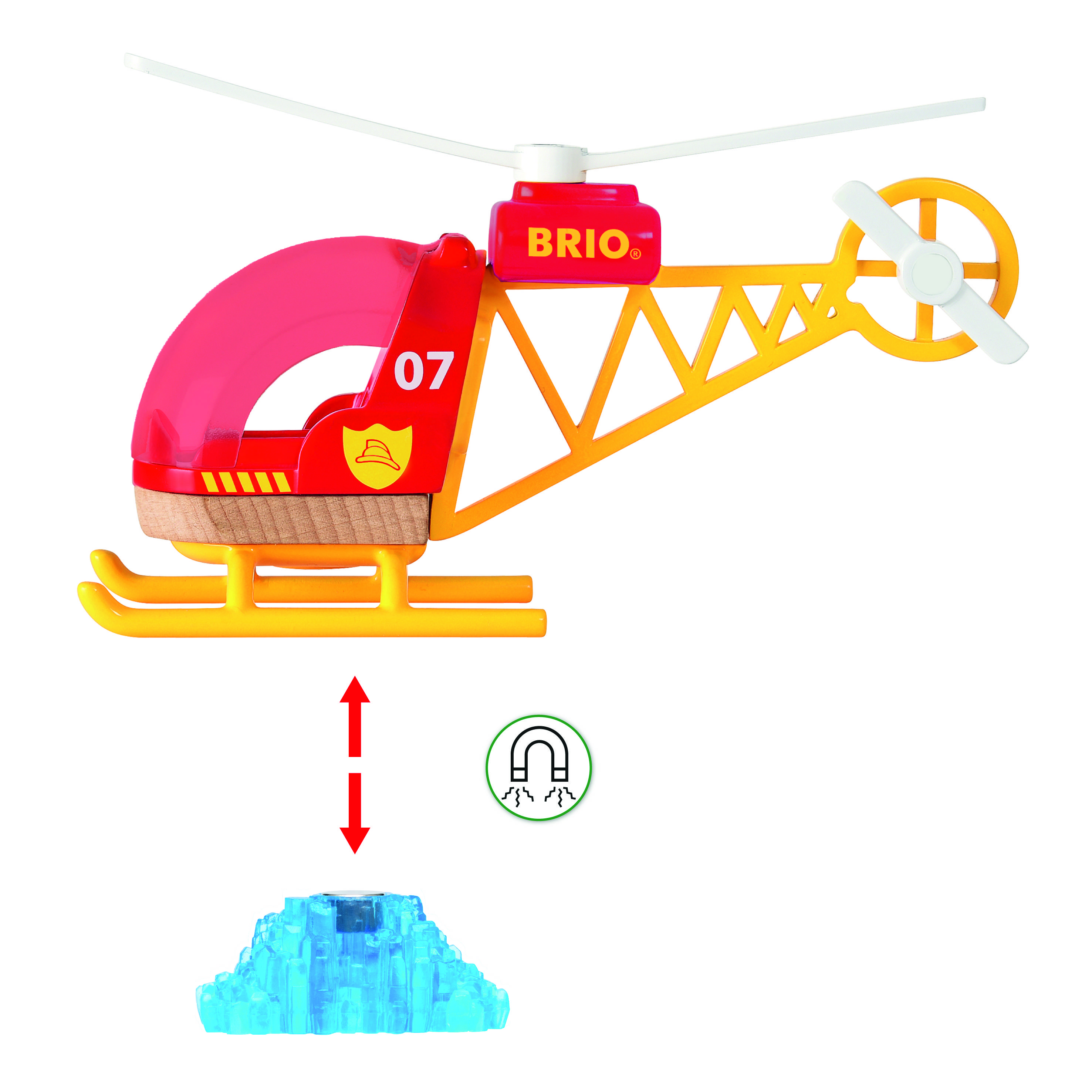 Hračkářská helikoptéra od firmy BRIO s červenou kabinou a žlutým rámem. Pod vrtulníkem vznáší magnetický modrý předmět.