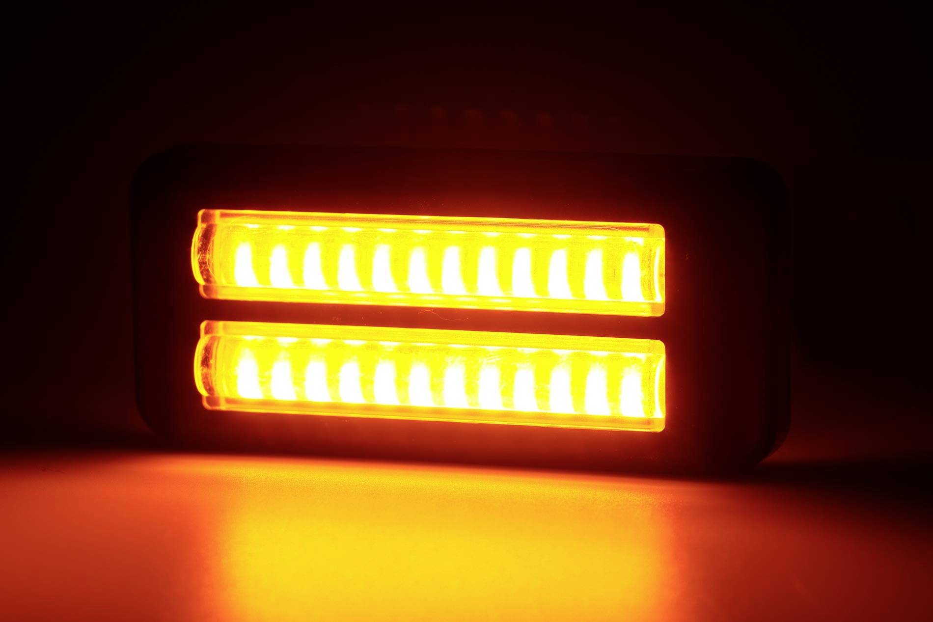 Dva paralelní oranžově svítící LED pásky na tmavém pozadí.