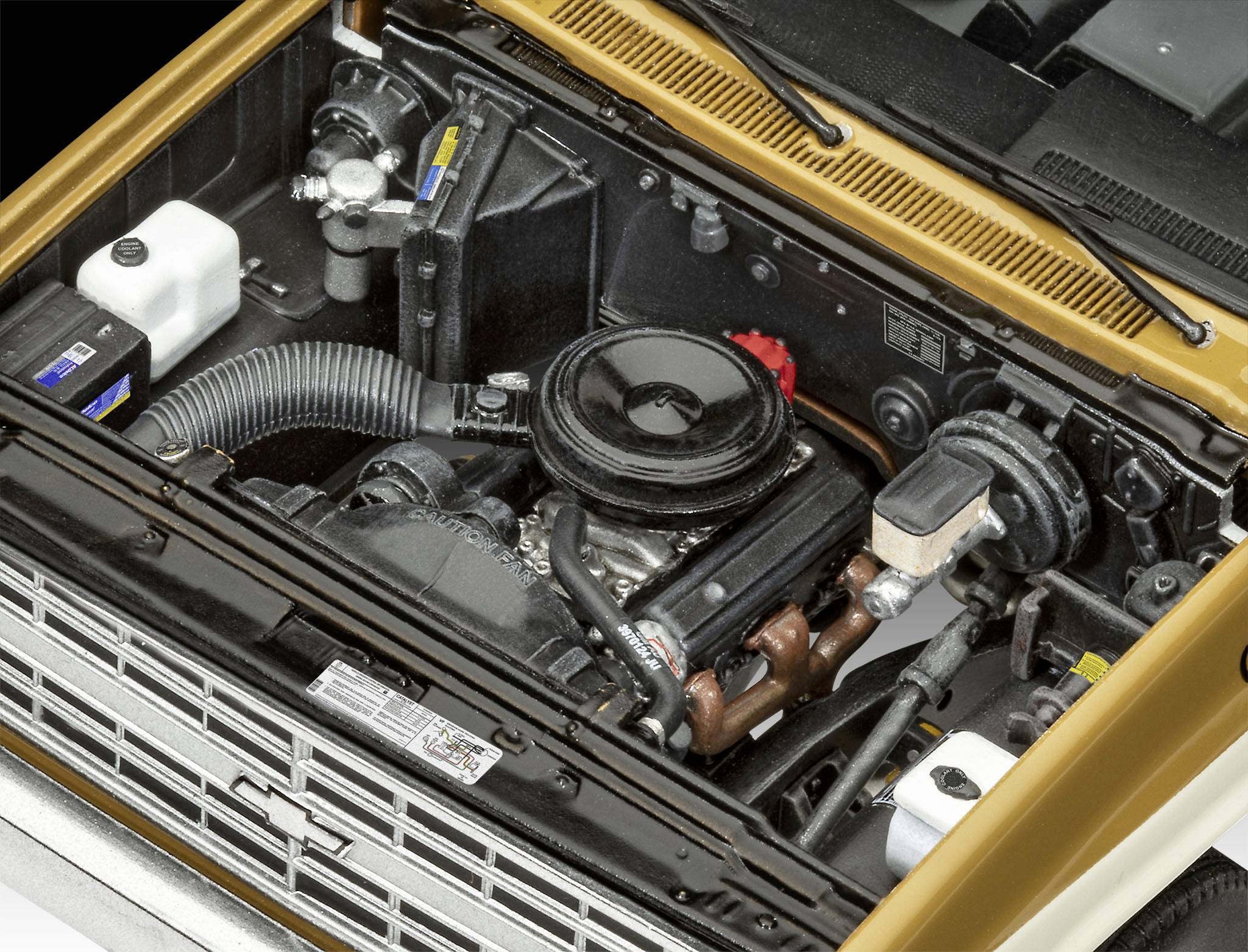 Motorový prostor automobilu s viditelným motorem, baterií a nádobkami chladicí kapaliny. Hlavní zaměření na detaily motorových komponent.