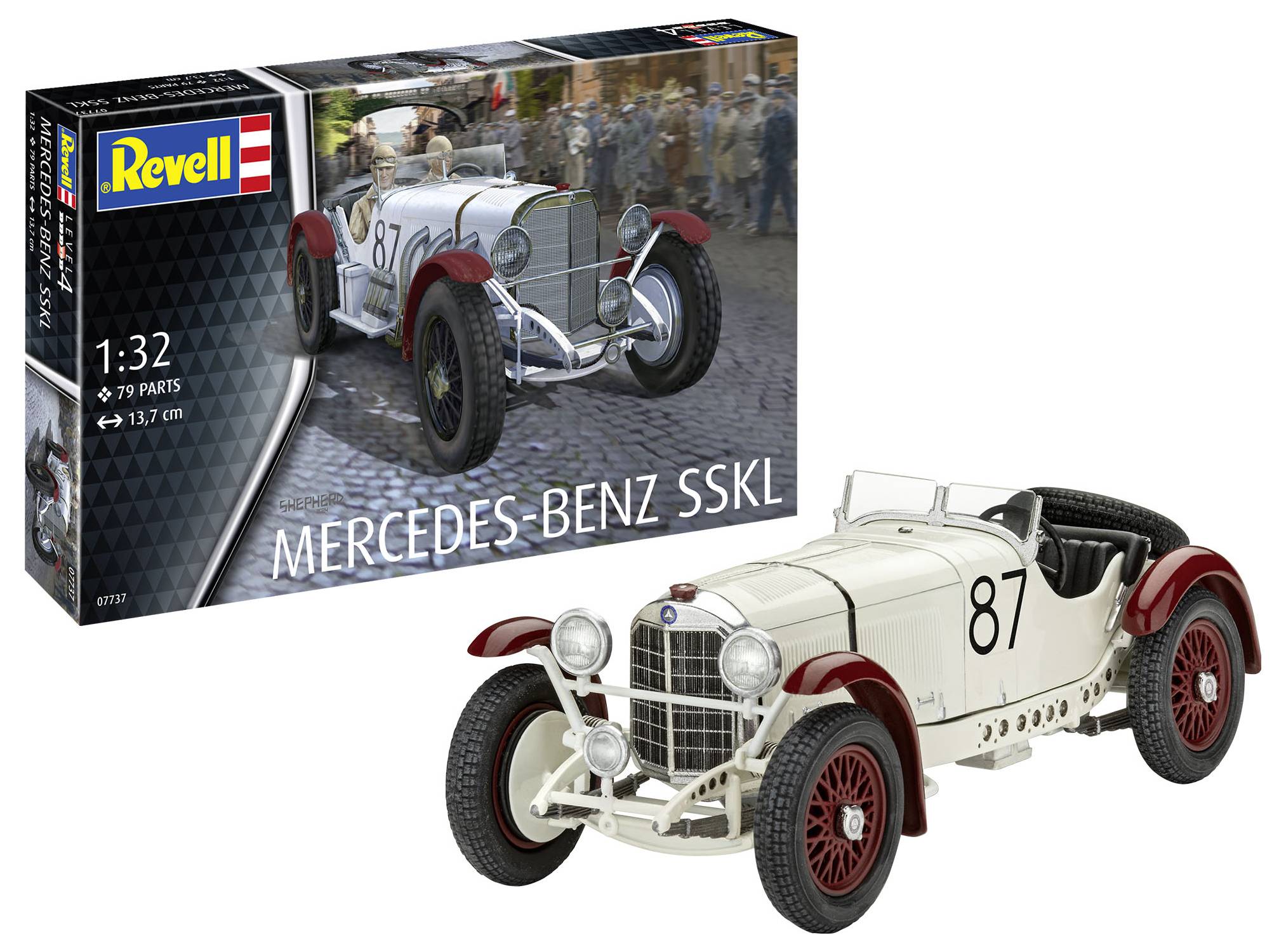 Model bílého závodního vozu Mercedes-Benz SSKL od firmy Revell v měřítku 1:32 s červeným diskem kola. Balení v pozadí.
