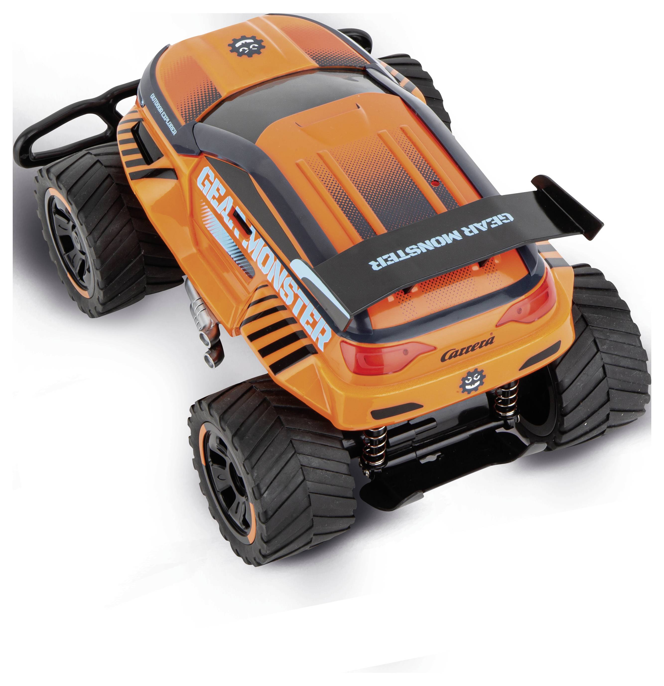 Oranžové hračkářské auto s nápisem 'Grav Monster'. Má velká terénní kola a robustní podvozek.