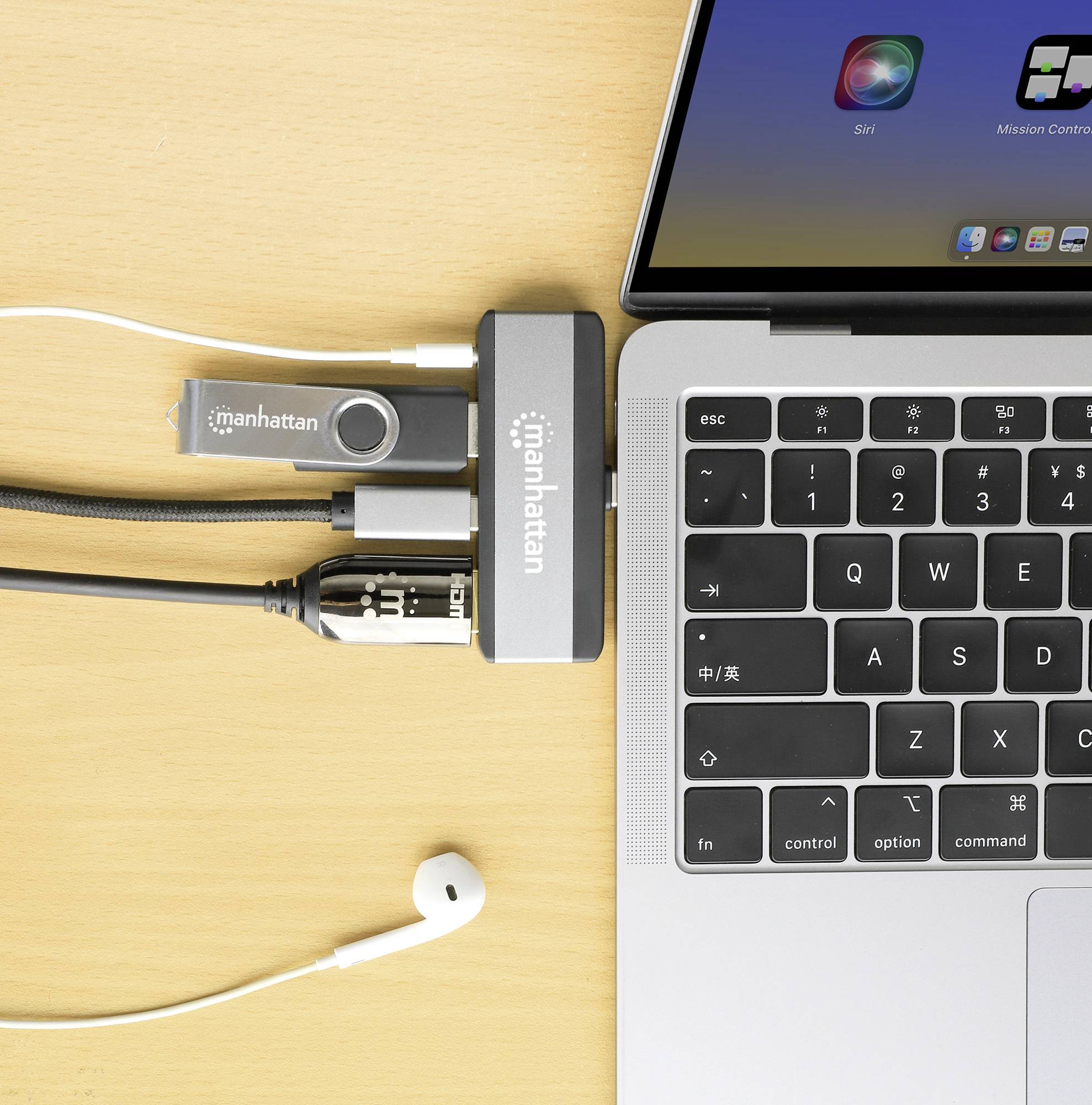 Počítač s připojeným USB hubem, propojený kabely a USB flashdiskem, vedle něj sluchátko. Pracoviště s technikou.
