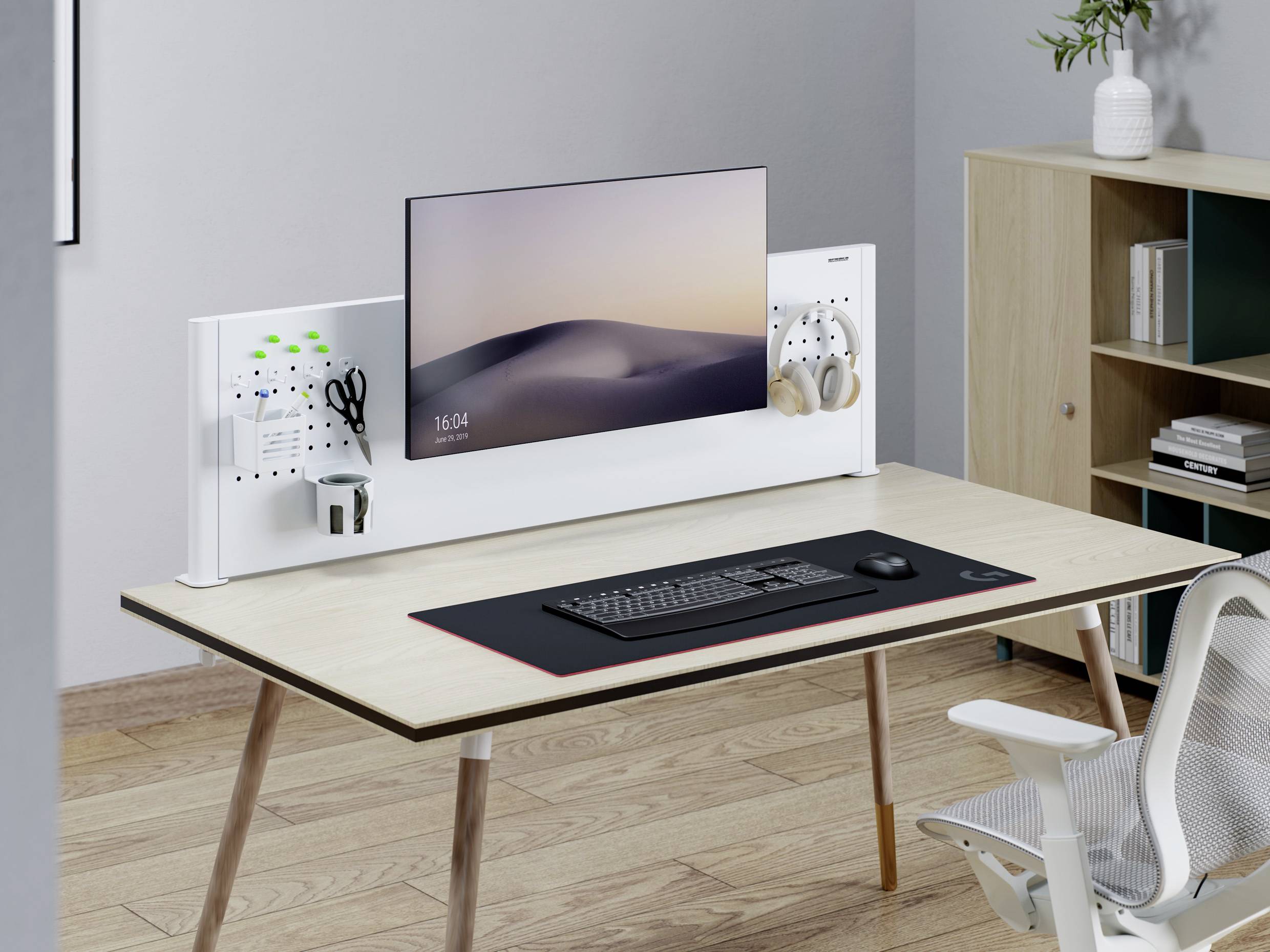 Moderní pracovní sestava s plochým monitorem, klávesnicí, myší a sluchátky na upravené, minimalistické pracovní ploše.