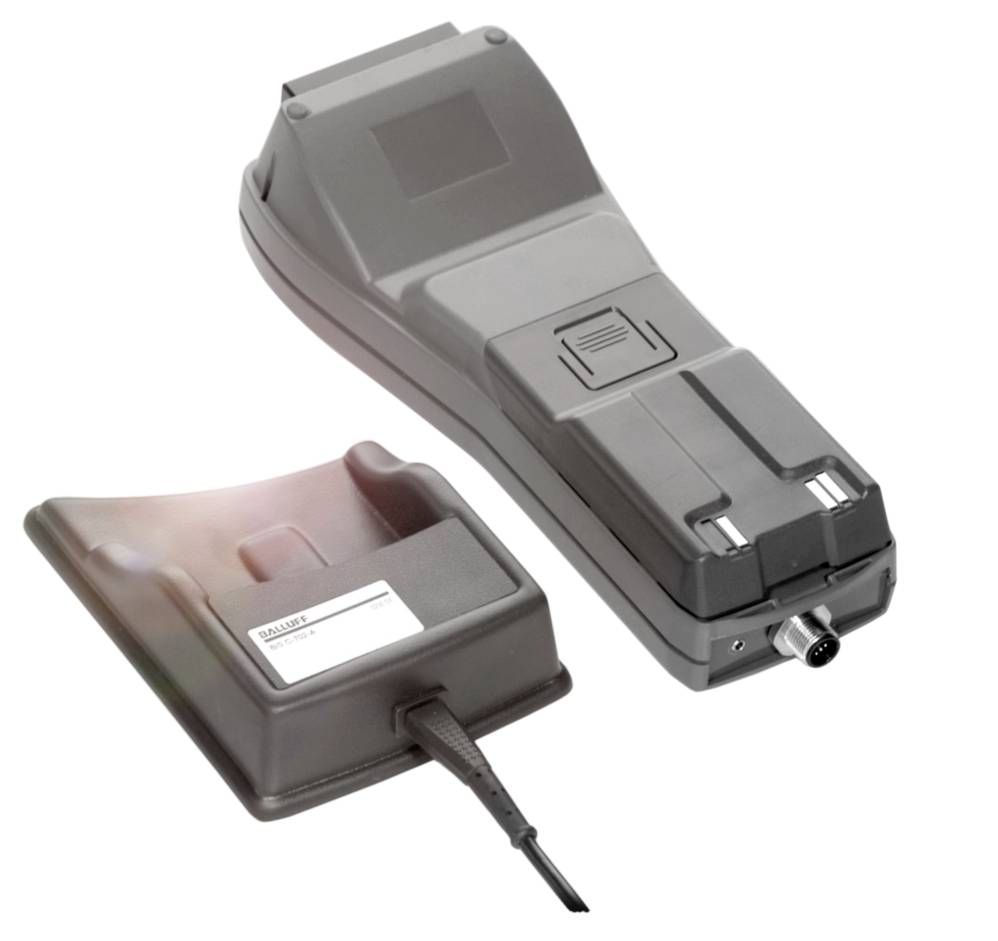 Šedý ruční skener s dokovací stanicí, propojený kabelem. Skener má tlačítka a připojovací zdířku.