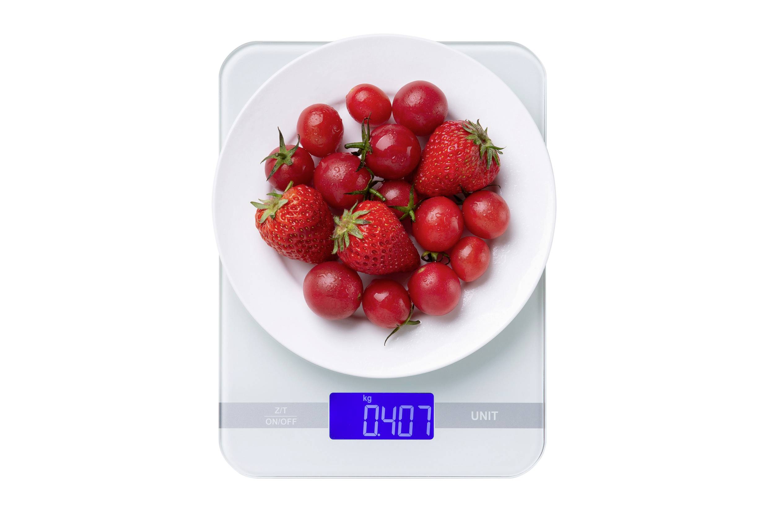 Bílá mísa plná jahod a cherry rajčat stojí na digitální váze, která zobrazuje '0,407 kg' modře.