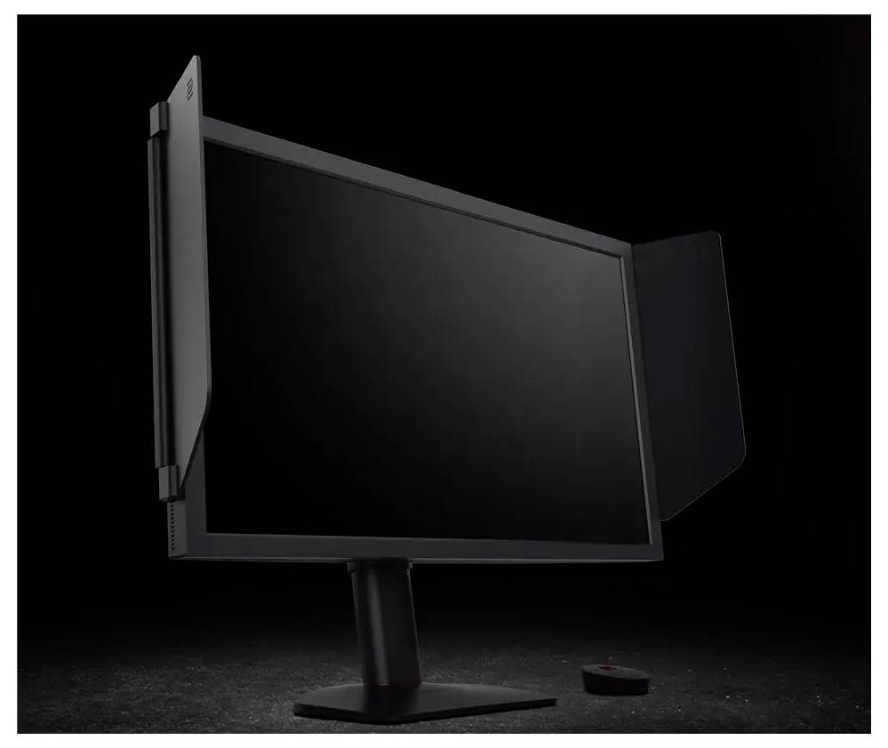 Černý monitor s připevněnou soukromým filtrem, zobrazený na černém pozadí. Malý kulatý předmět je umístěn poblíž základny monitoru.