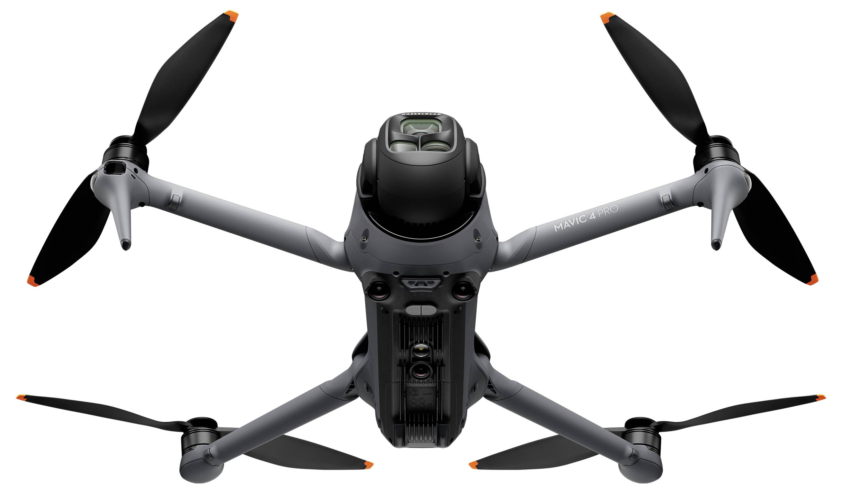 Šedý dron se čtyřmi vrtulemi, pohled zespodu, s viditelnou kamerou a senzory, určený pro leteckou fotografii a videografii.