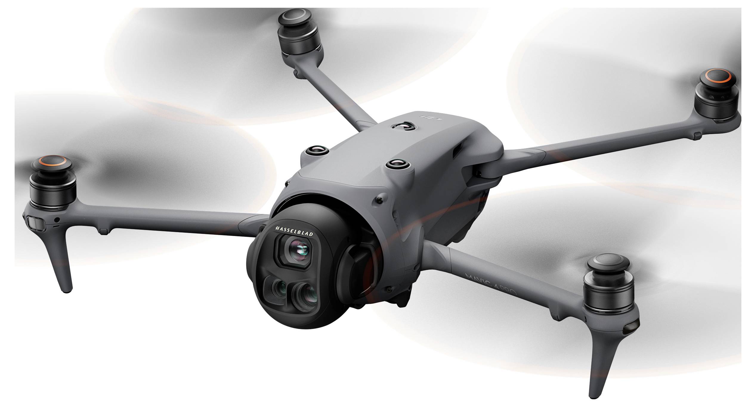 Černý dron ve vzduchu se čtyřmi vrtulemi, s kamerou umístěnou vpředu.