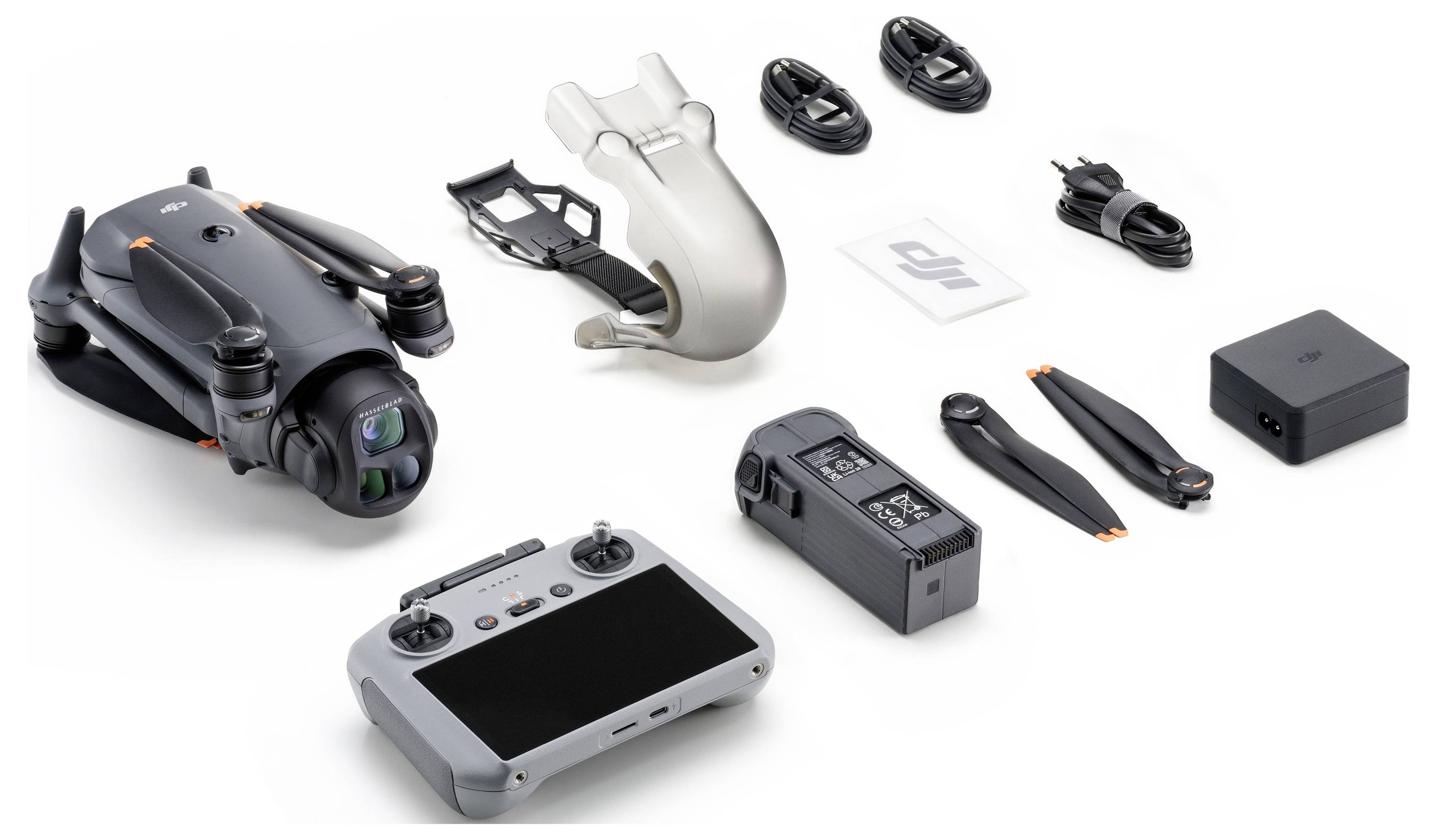 Dronový set skládající se z překládaného dronu, dálkového ovladače, ochranného krytu kamery, baterie, vrtulí, kabelů, nabíječky a napájecího adaptéru.