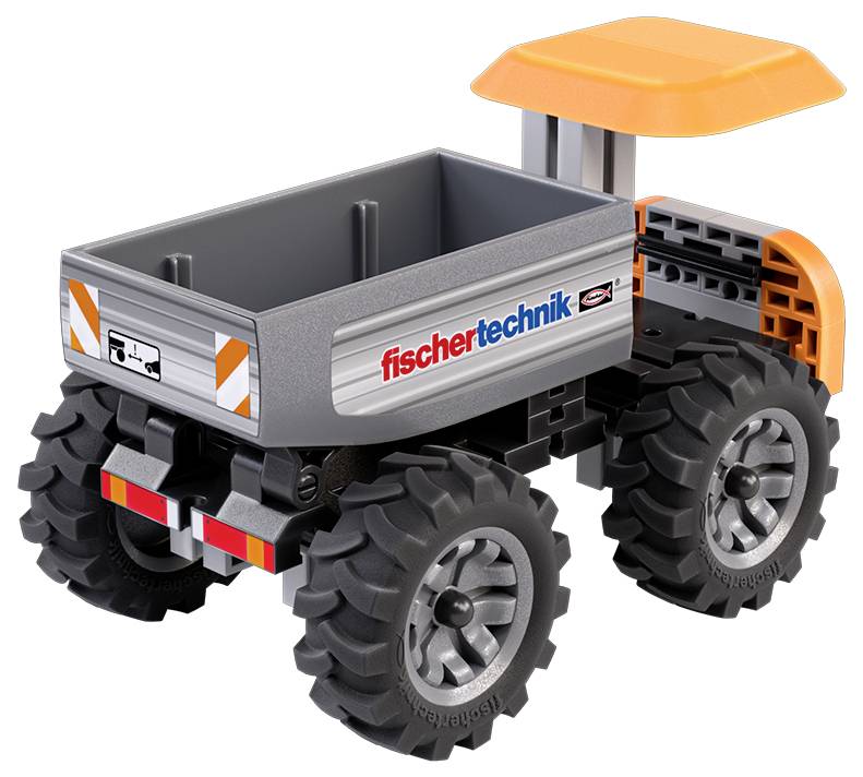 Model nákladního vozu s šedou nákladní plochou, velkými černými koly a oranžovou střechou, na jehož boku je nápis „fischertechnik".