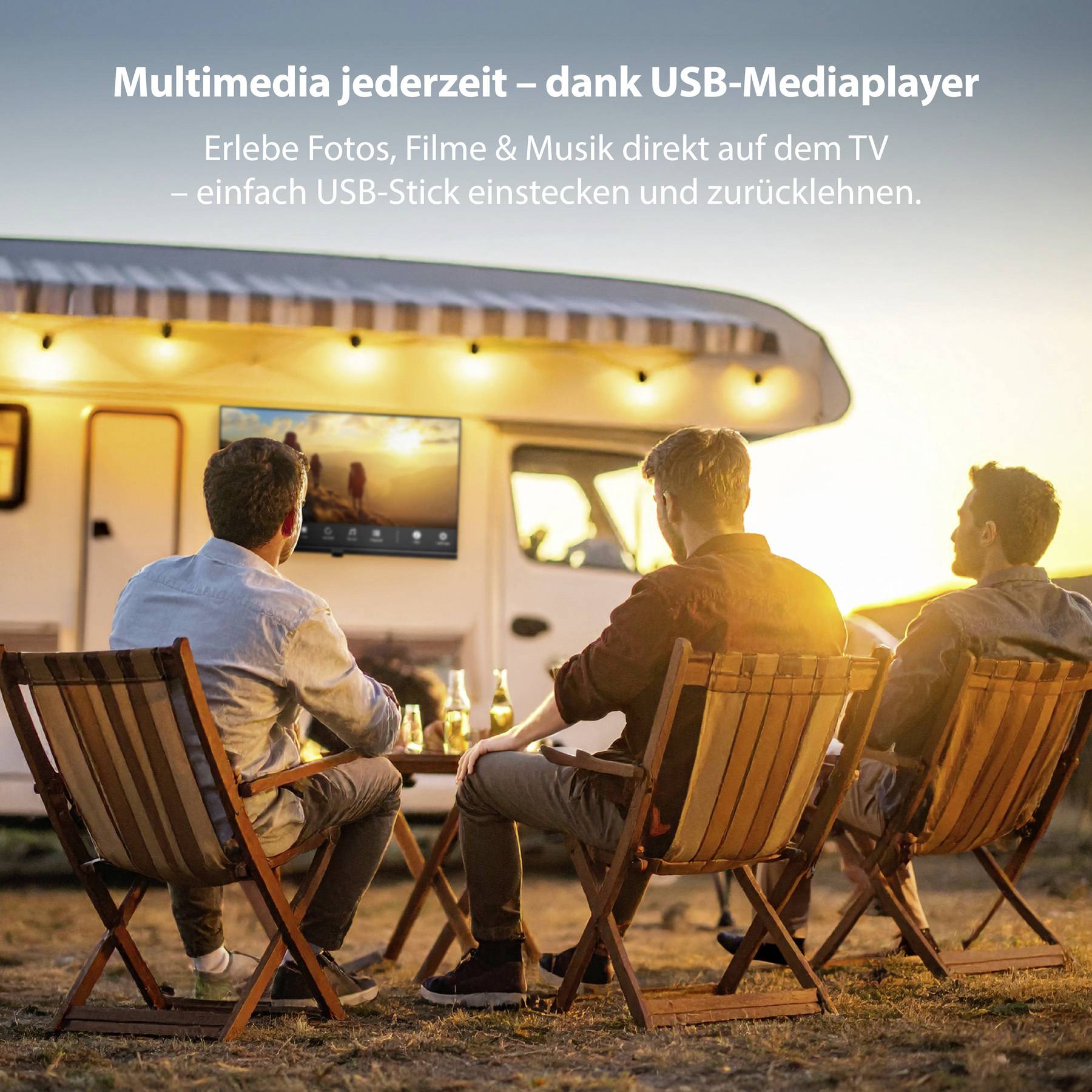 Tři lidé sedí venku před obytným vozem a sledují televizi. Text v němčině propaguje USB mediální přehrávač pro sledování médií.