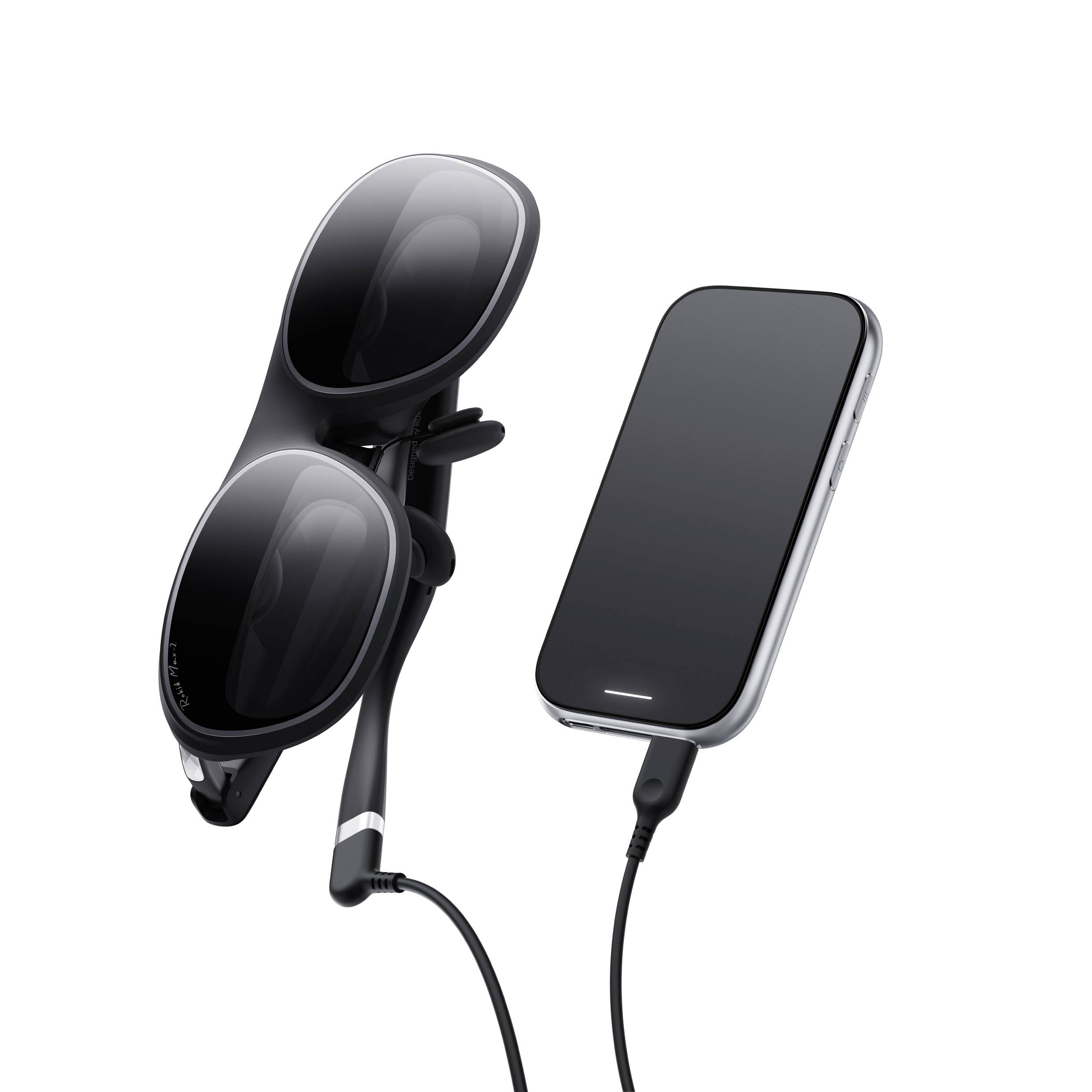 Elegantní černé chytré brýle se třemi čočkami, připojené krátkým kabelem k černému smartphonu, které prezentují moderní nositelnou technologii.