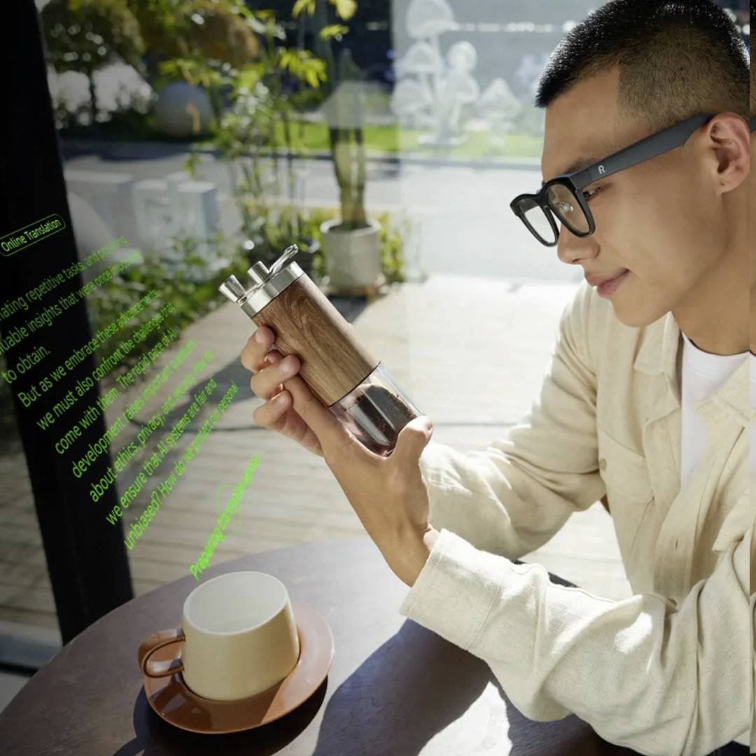 Osoba sedící venku, která drží dřevěný mlýnek na pepř nad stolem s šálkem a podšálkem. Sluneční světlo vrhá stíny na scénu.