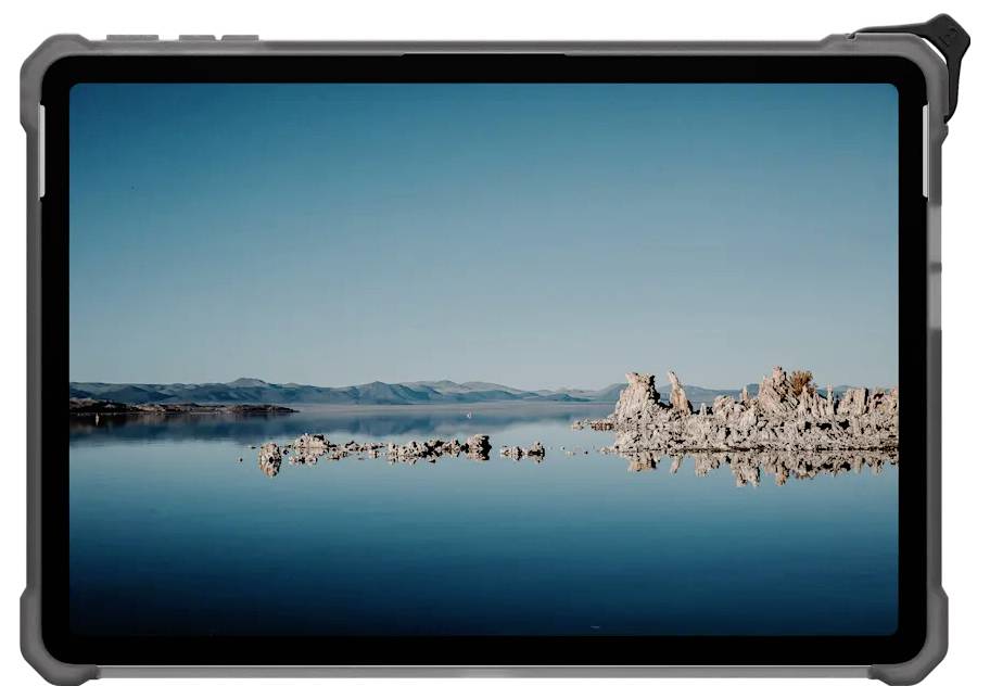 Tablet zobrazuje klidnou krajinnou fotografii s klidným jezerem, skalními útvary a vzdálenými horami pod jasně modrou oblohou.