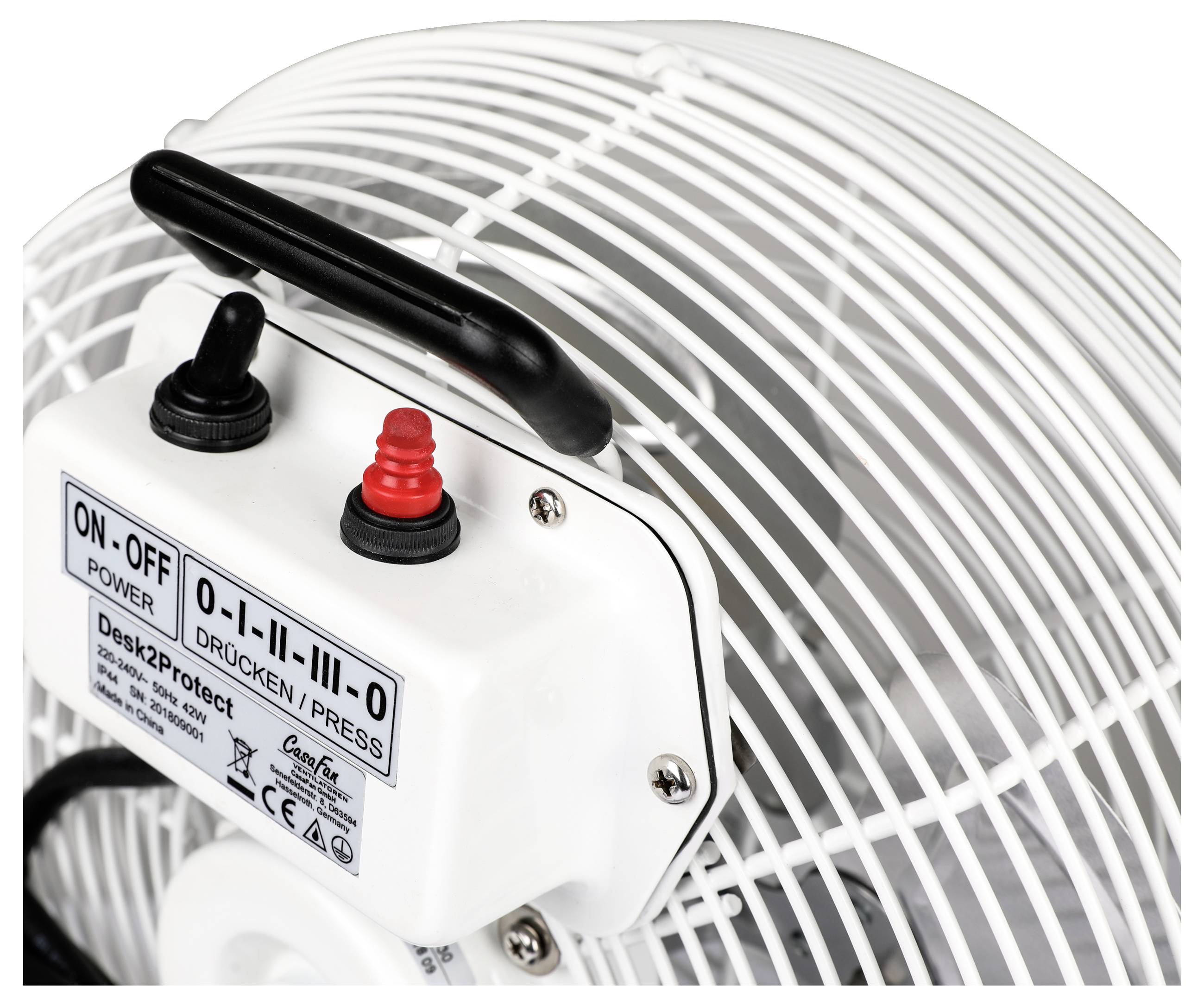Detail elektrického bílého ventilátoru s ovládacím panelem, který má dva přepínače pro napájení a intenzitu. Ventilátor je vybaven ochranným krytem.