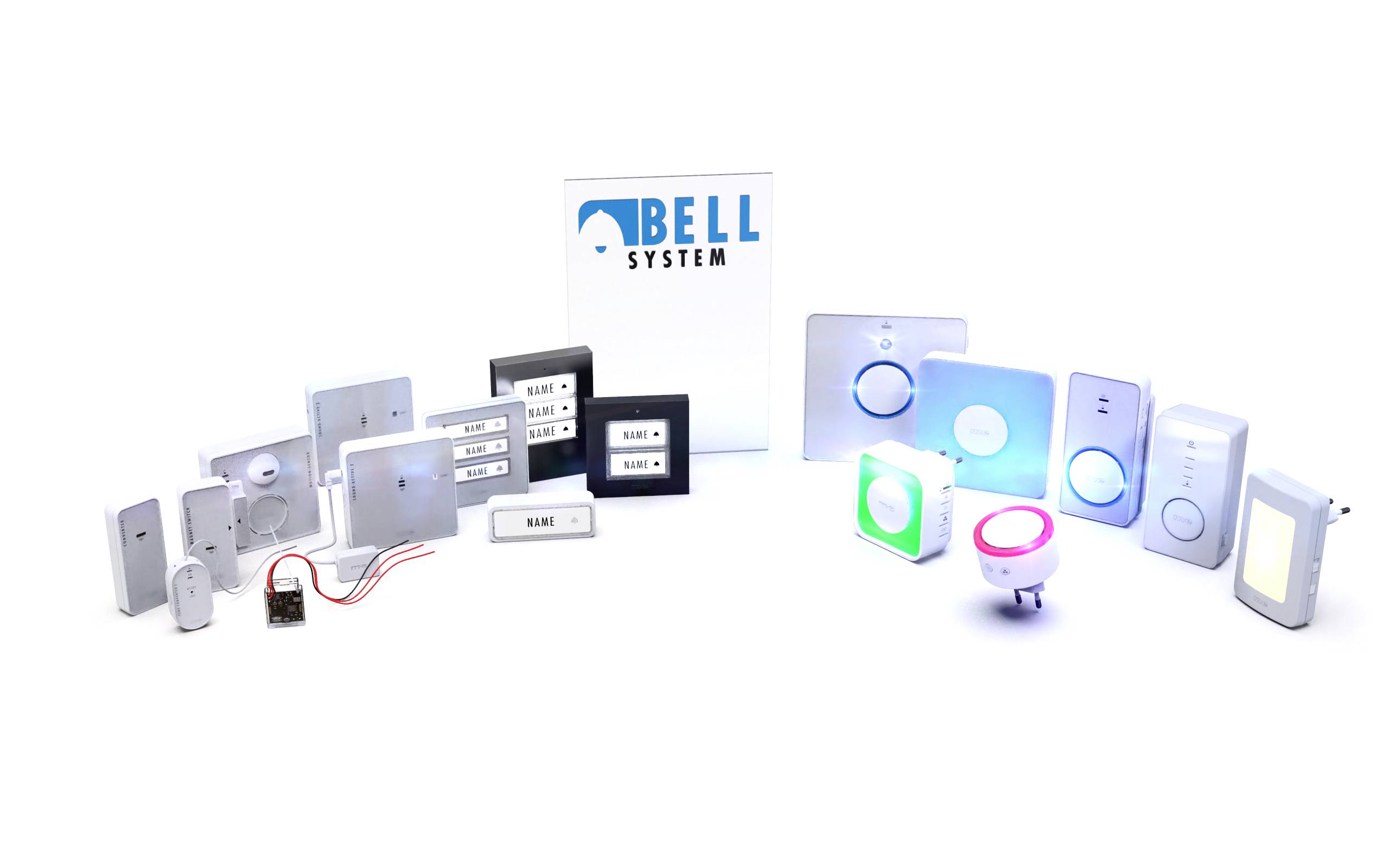 Sbírka různých bílých a šedých systémů domovních zvonků a příslušenství. Uprostřed stojí krabice s nápisem 'Bell System'.