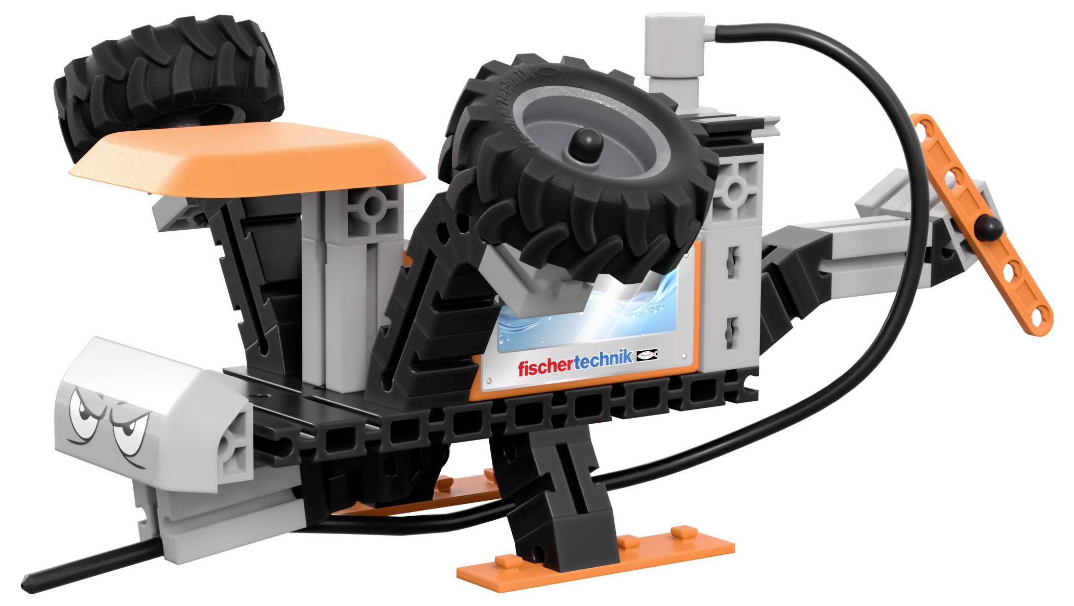 Malý robotický model vozidla s černým podvozkem, oranžovou střechou, dvěma velkými koly nahoře a štítkem „fischertechnik" na boku.