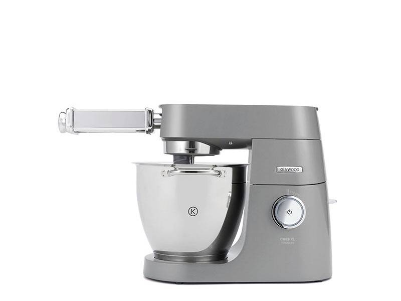 Šedý stolní mixér značky KENWOOD s nerezovou mísou, vybavený nástavcem nahoře pro další funkce.