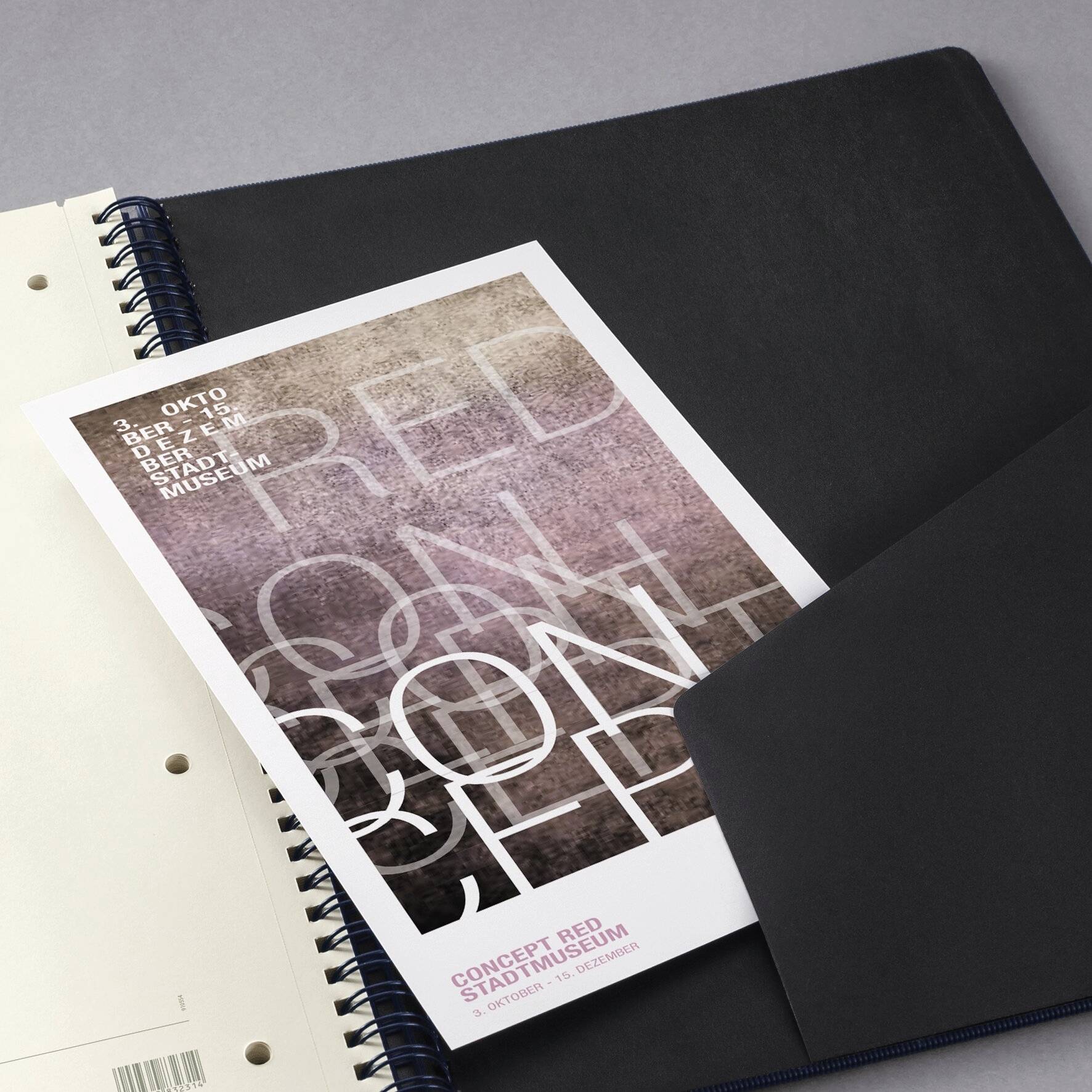 Brožura s názvem "Koncept Red Stadtmuseum" na spirálově vázaném notebooku, s rozmazaným textem v překryvných odstínech červené a bílé.